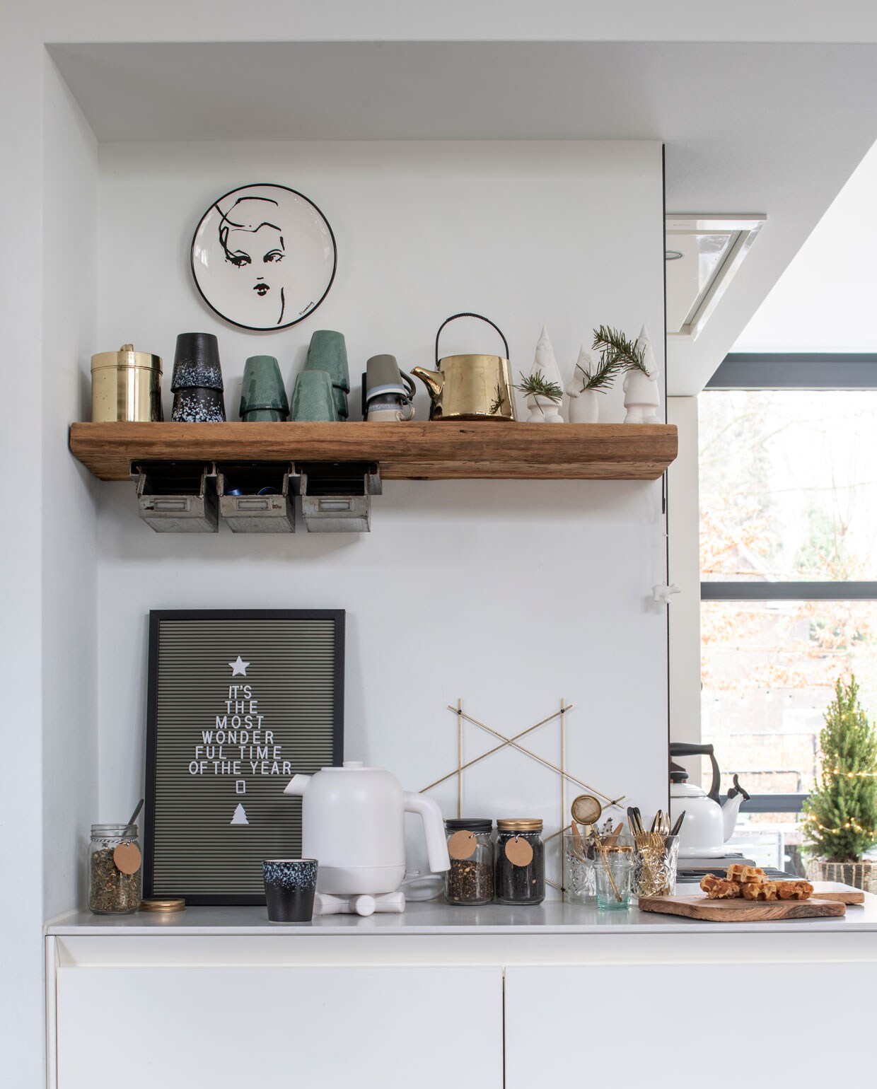 Houten wandplank met stalen opbergbakje gemaakt door Robuust Maatwerk. Bord aan de muur Kwantum, goudkleurig potje Sissy-Boy, bekers en theepot HK Living, kabouters Hej Living, waterkoker Hema, gouden ster Søstrene Gene.