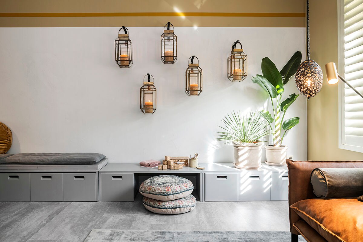 Op de muur: Levis Ambiance Beton Effect (). Lantaarns (Riverdale), opbergbank (vtwonen collectie), zitkussen (Bloomingville).