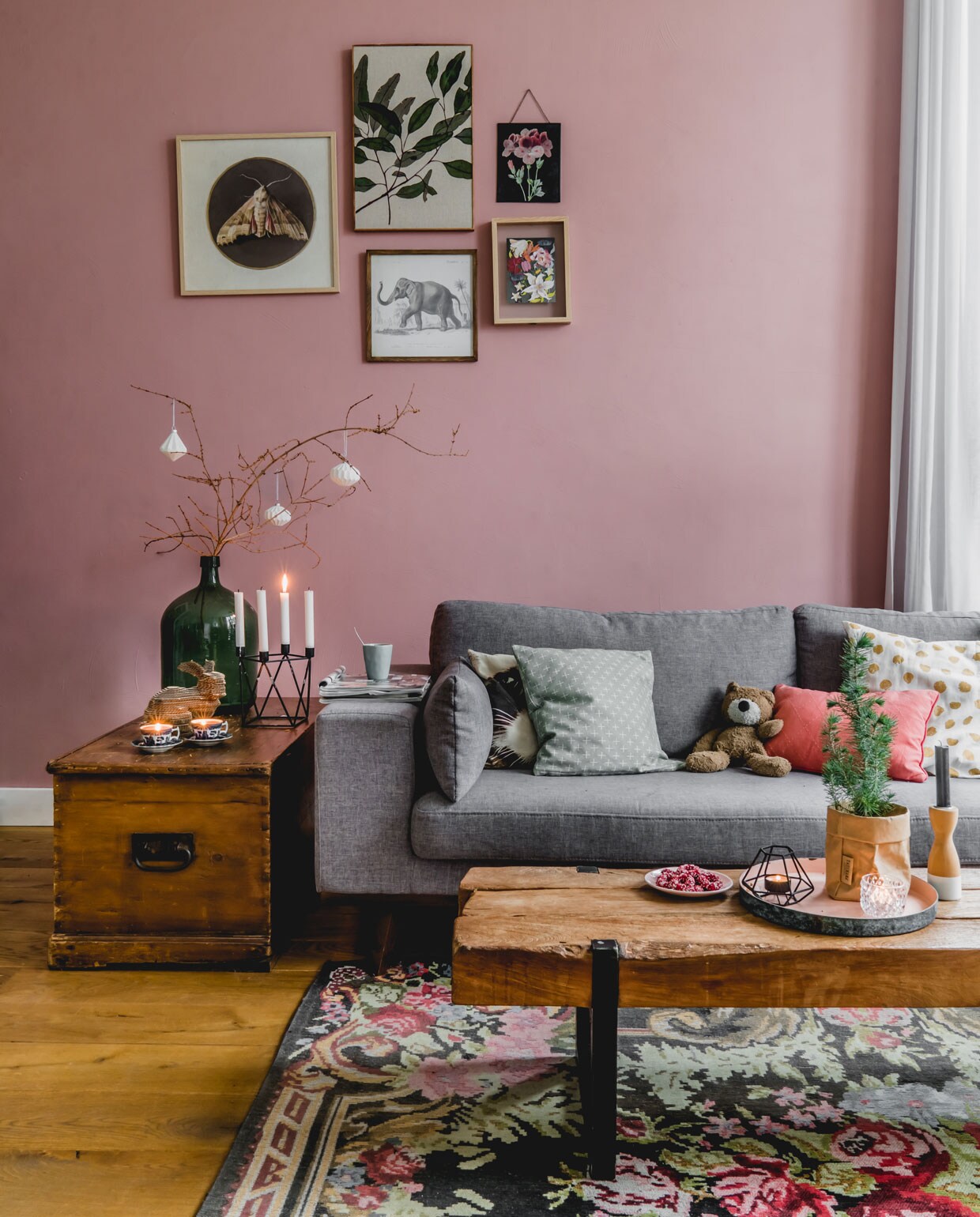 De oude suitedeuren vonden ze terug in de schuur. Muurverf kleur Ritueel van Histor. Bank en gouden lamp van wehkamp.nl, kleed en lijsten met prints op de muur van Kwantum, dekenkist van Marjoleins oma, tafel van De Troubadour. De tak komt in kerstsfeer met decoraties, die ze zelf maakten met een 3D-printer. Vaas van Hof Tongerlo, kandelaar cadeau gekregen, konijn zelfgemaakt, herkomst draadmand onbekend.