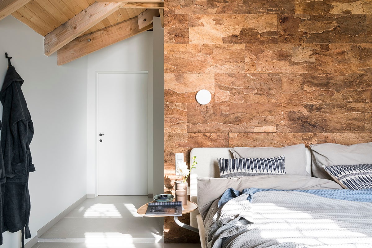 Vloer – Orotava uit Nuances collectie (). Kurkwand – Maximo uit Raw collectie (). Wandlamp (Lucide), bed – Fly (Velda), wandhaak (Gamma), badjas (Walra), dekbed (vtwonen collectie), blauwe sprei (Heckett &amp; Lane), grijze sprei (Vandyck), kussen op bed (HKliving).