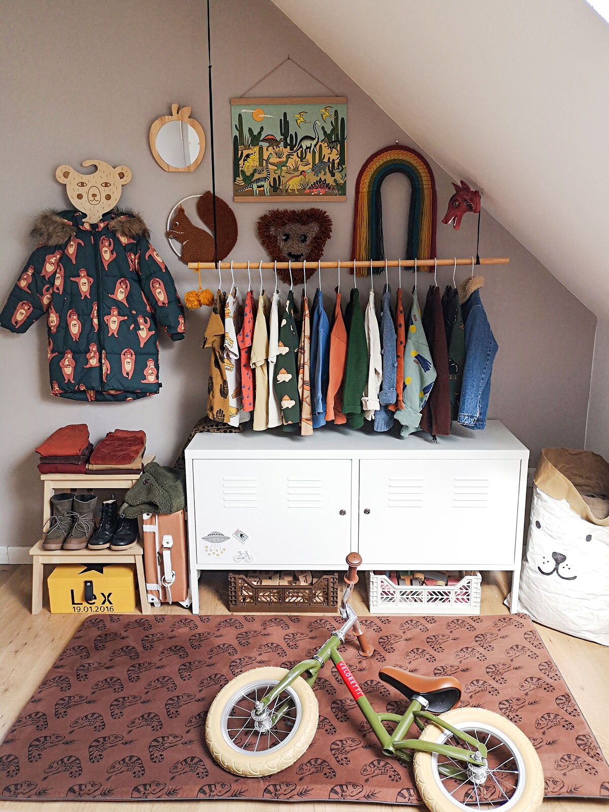 Witte lockerkast (Ikea), bruine speelmat – Night Jungle (ByAlex i.s.m. Sproet &amp; Sprout), kaki loopfiets (Veloretti).