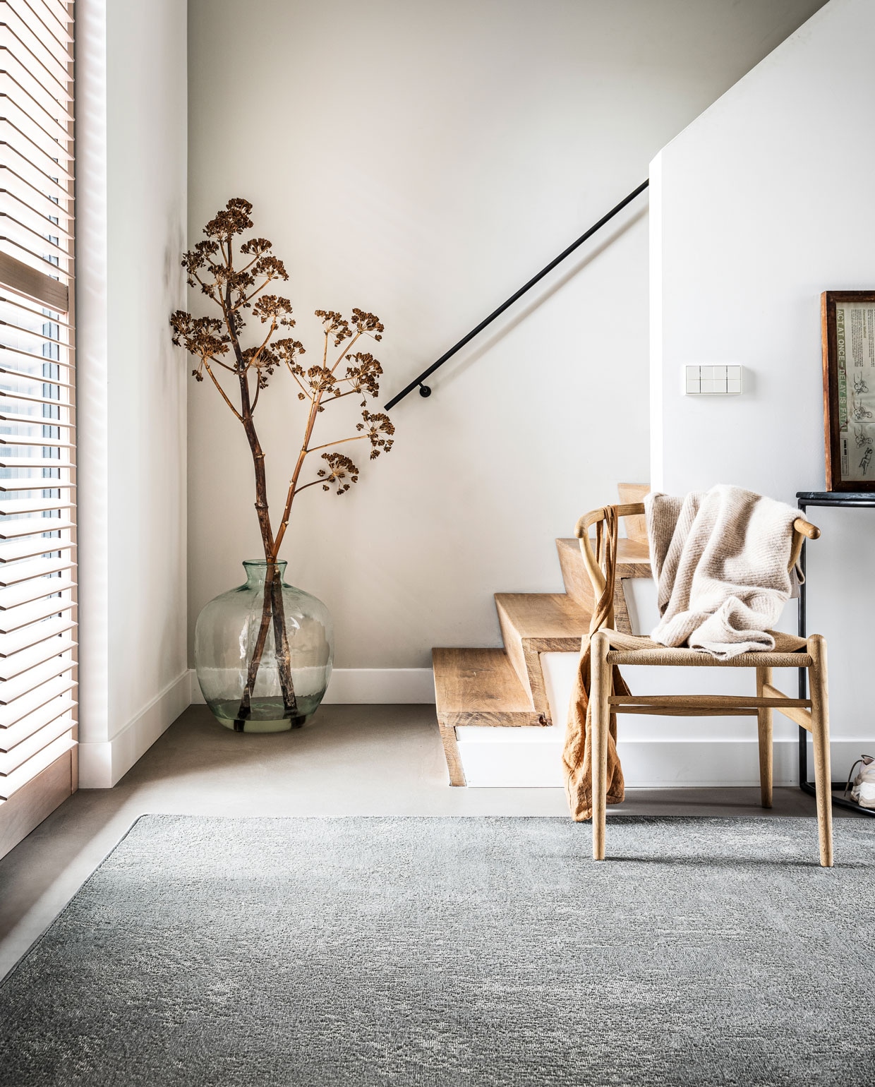 Vloerkleed Stonewashed Zinc, ook in Pebble en Washed Black, op maat gemaakt met gefestonneerde rand, 200×300 cm. Wishbone Chair (Hans J. Wegner bij misterdesign.be), zwarte bijzettafel (hetkabinet.nl), tas (fishonthemoon.com), vest (stories.com), overig privébezit.