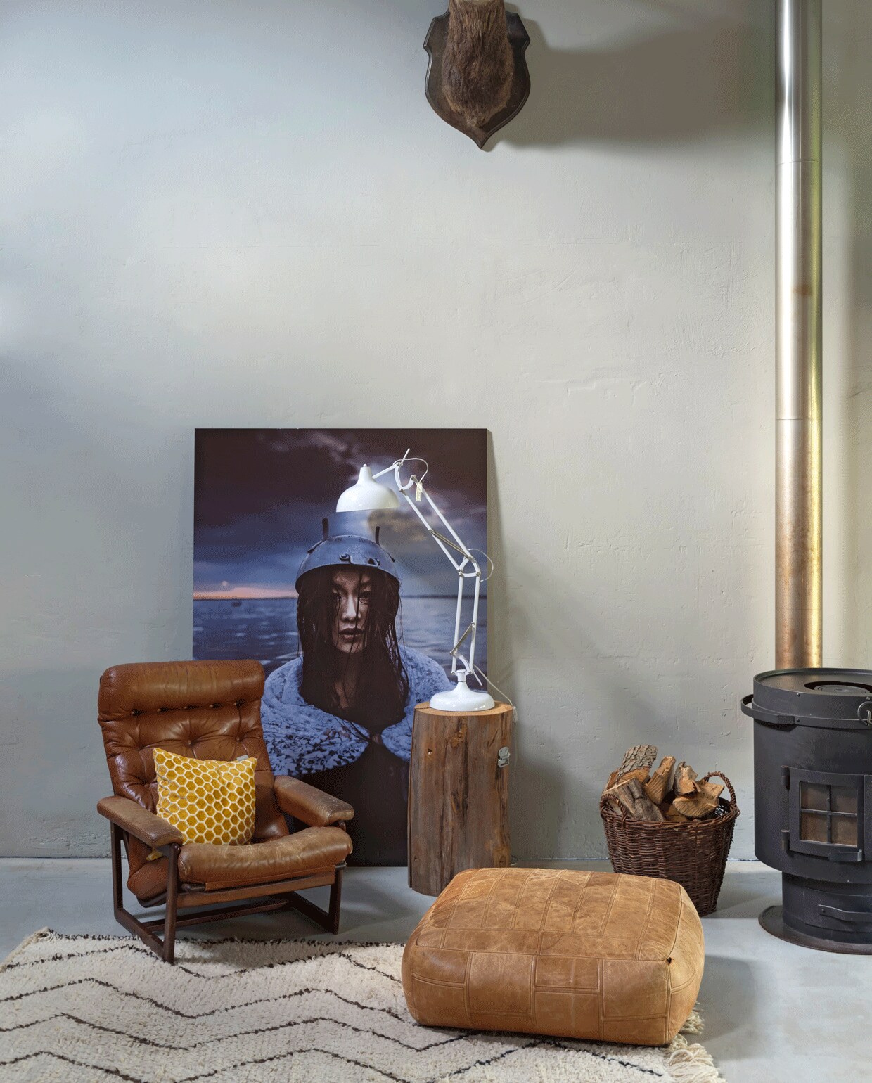 Hertenkop via ebay.com, foto van Hugo, beschikbaar via hugogoudswaard.com, witte lamp van Loods5, geel kussen van Zuiver, houtmand is een erfstuk.