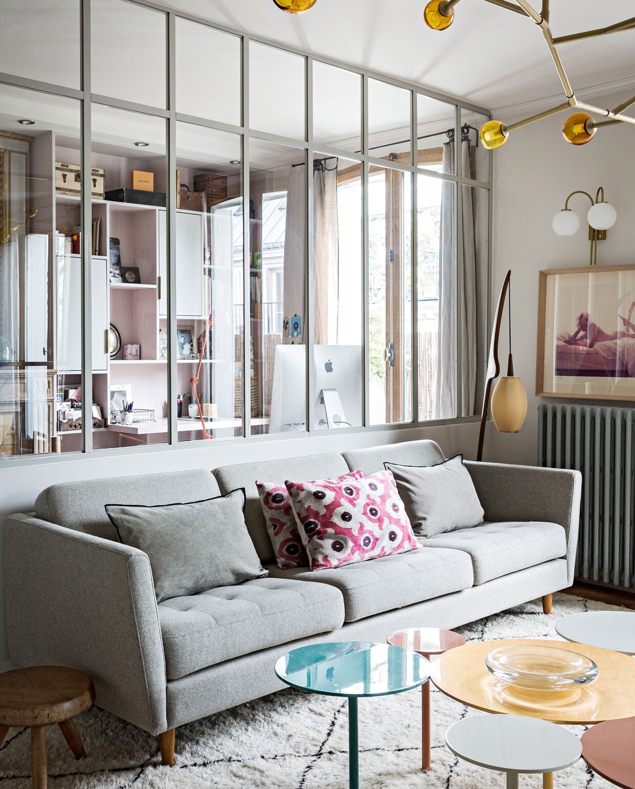 De zetel is van BoConcept, de kussens komen van Maison de Vacances en Le Monde Sauvage. Plafondlamp en salontafel zijn van Damien Langlois-Meurinne voor Pouenat. Rechts naast de zetel de Praying Mantis vloerlamp van Jean Rispal. Tapijt uit Marrakech, overig tweedehands vondsten.