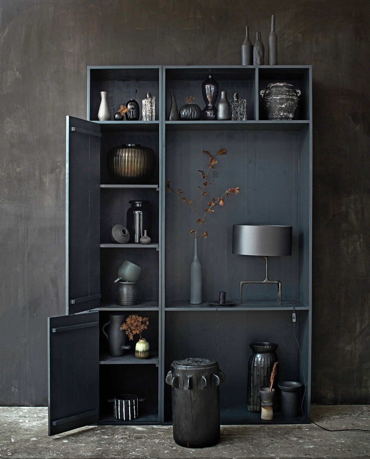 Muurverf kleur Onyx (bauwerk.com). Op de kast: vaas links (covanderhorst.nl), vaas midden (edha-interieur.nl), vaas rechts (zarahome.com). Zwarte kast (com-anders.nl). Van links naar rechts en van boven naar onder in de kast: gestippelde vaas (thingsilikethingsilove.com), klein zwart vaasje zwart, hoogglans zwart vaasje (hm.com), zwart-witte vaas met structuur (serax.com), decoratie hoorn (thingsilikethingsilove.com), geribbelde vaas (covanderhorst.nl), grote glazen vaas (loods5.nl), vaasje met structuur (thingsilikethingsilove.com), zwart-witte vaas met structuur (serax.com), grote zwarte vaas met witte vlekken van Eigen en Anders (loods5.nl), grote bruine vaas met ribbel (covanderhorst.nl), liggend vaasje grote glazen vaas (hm.com), klein vaasje met tuit van Lindform Sweden (maisonnl.com), vaasje in bloempot (serax.com), bloempot (loods5.nl), hoge vaas naast lamp (zarahome.com), bord (hm.com), klosje (sostrenegrene.com), lamp (covanderhorst.nl), matzwarte hoge vaas (serax.com), legergroen vaasje met kleurverloop (thingsilikethingsilove.com), brede zwart-wit gestreepte vaas van Serax (loods5.nl), grote vaas (covanderhorst.nl), vaas met zandlopervorm van Ildikó Horváth (studiopansa.com), zwarte vaas (hm.com). Zwarte kruk, 50×35 cm (hxØ) (casagitane.com). Takken in vaas (tuinvanjudith.wordpress.com).