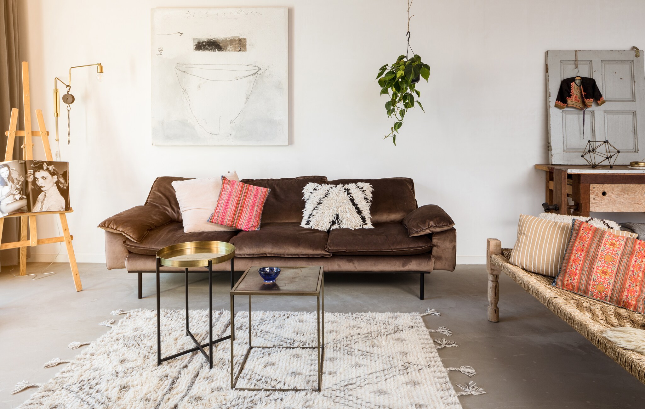 Boek op ezel Kate Moss by Mario Testino. Het schilderij van René van der Hoofd is aangeschaft toen Marieke en Eddy gingen samenwonen. Zetel en zwart-wit kussen van HK Living via Mariekes shop. Lichtroze kussen House Doctor, kleurige kussens beiden Aai Made with love. Lamp House Doctor, rond bijzettafeltje en tapijt HK Living, daybed en vierkant tafeltje BePureHome. Het blauwe schaaltje is gemaakt door Mariekes moeder. Bureau en oude deur van De Jutter in Ruinerwold, object op bureau van HK Living. Het jasje was een cadeau van Mariekes moeder en komt uit India, Mees heeft het nog aangehad toen hij klein was. Photo: Hans Mossel