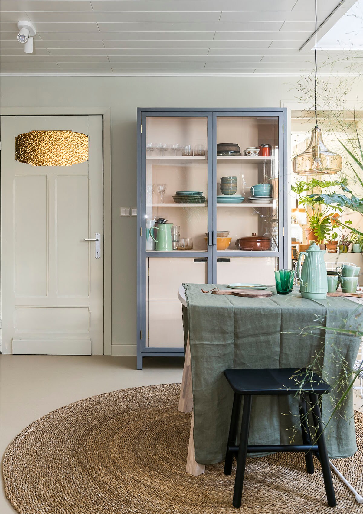 Vitrinekast (HKliving), hanglamp en tapijt (Bloomingville), kruk (vtwonen collectie), tafelkleed (Broste Copenhagen).