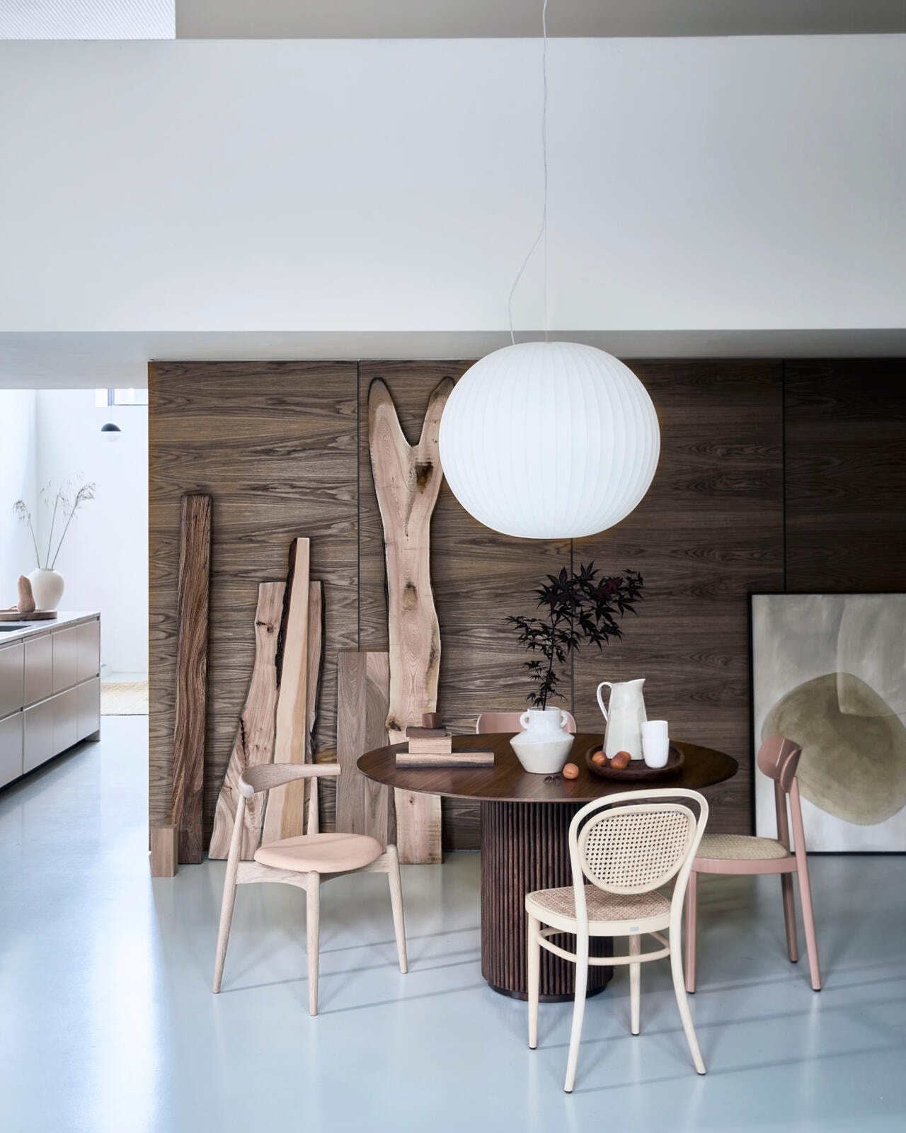 Teak- en eikenhouten eettafel Palais Royal van Asplund, 130×73 cm (Øxh) € 4116,-, hoogglans roze gelakte Thonet stoel nr 118 € 556,-, Thonet stoel 215R € 840,20, lichte houten stoel Elbow met leren zitting van Carl Hansen € 982,- (misterdesign.nl). Hanglamp Nelson Ball Bubble van Hay, Ø 68 cm € 758,-, vaas Connor van Bloomingville € 49,90 (vtwonen.nl). Stukken hout ter decoratie, prijs op aanvraag (fijnhout.nl). Vaas in keuken € 45,-, kan € 39,95 (zarahome.com). Houten schaal van Zanat € 367,- (kasstoor.nl). Bekers Arcs per 2 € 39,- (bolia.com). Schilderij onderdeel van een tweeluik, prijs op aanvraag (tessaderijk.com). vtwonen 2020-08 | Fotografie Jeroen van der Spek, styling Cleo Scheulderman