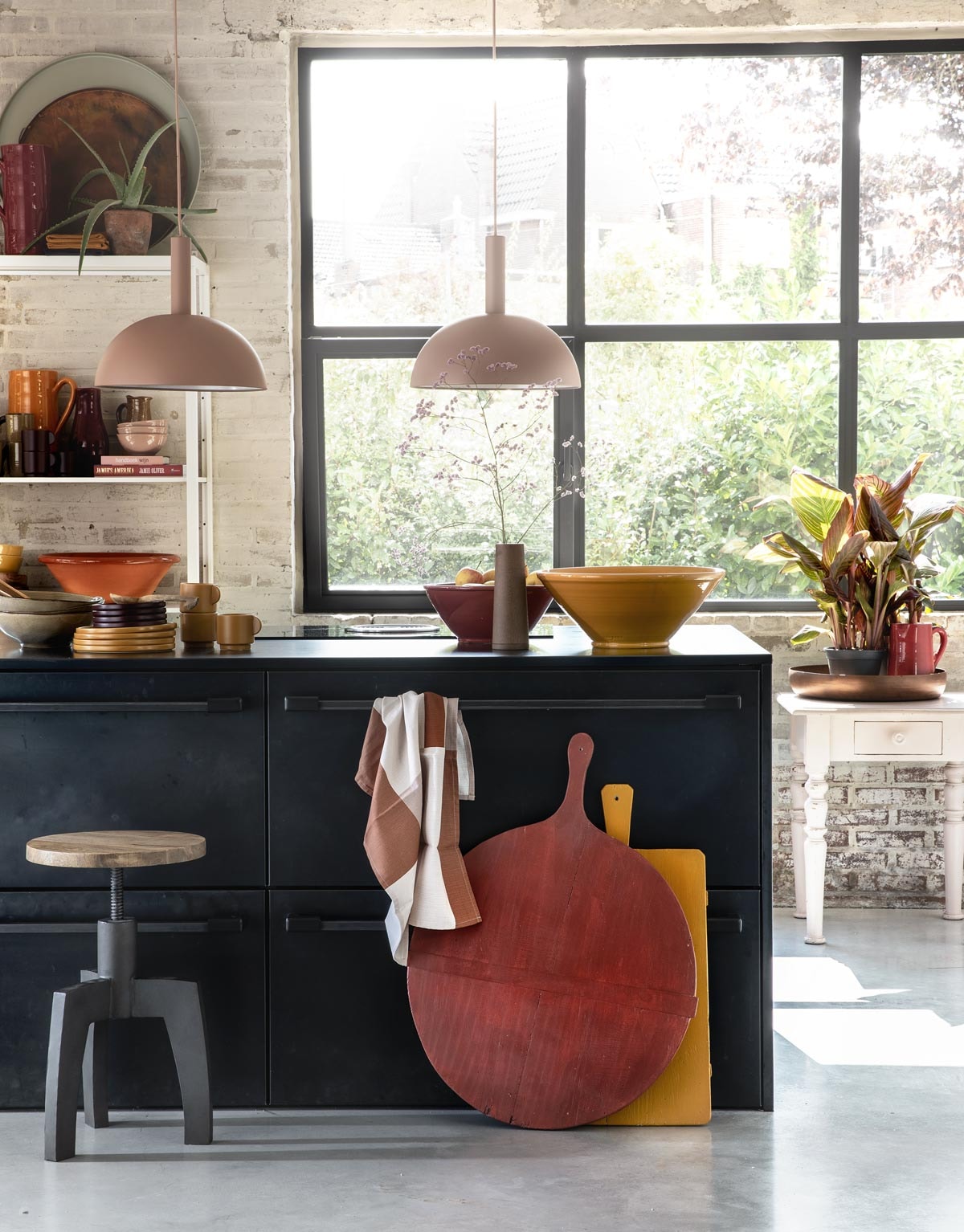 Zachtroze hanglampen Dome Shade van Ferm Living inclusief roze fitting High (vtwonen.nl). Draaikruk Space van BepureHome (Woondock). Grote oude kaasplanken (H&amp;M Home), gelakt met Perfection zijdeglans lak in dieprood en mosterdgeel (Histor). Theedoek, okergele kopjes, okergele borden, donkerpaarse borden (H&amp;M Home). Okergele schaal, donkerrode schaal (In-Petto). Beige schalen (Intratuin). Bovenop de kast: grote donkerrode kan (In-Petto), theedoeken in okergeel en donkerpaars (H&amp;M Home), koperkleurige schaal van BePureHome, zachtgroene schaal (Woondock). Midden in de kast: zachtroze schaaltjes, okergele kan (In-Petto). Donkerpaarse kopjes (H&amp;M Home). Donkerrode karaf Nikki, lichtbruine karaf (Intratuin). Beige kan (Intratuin). Onder in de kast: terracotta schaal, okergele diepe borden (In-Petto). Zachtroze tafeltje (Combitex). Koperkleurige schaal Big Waitress van BePureHome (Woondock). Donkerrode kleine kan (In-Petto). Kamerplanten Canna Hybride (Intratuin). De keuken is een eigen ontwerp van de bewoners, binnenwerk van hout, blad en kasten afgewerkt met blauw staal. Overig privébezit. Zachtroze hanglampen Dome Shade van Ferm Living inclusief roze fitting High (vtwonen.nl). Draaikruk Space van BepureHome (Woondock). Grote oude kaasplanken (H&amp;M Home), gelakt met Perfection zijdeglans lak in dieprood en mosterdgeel (Histor). Theedoek, okergele kopjes, okergele borden, donkerpaarse borden (H&amp;M Home). Okergele schaal, donkerrode schaal (In-Petto). Beige schalen (Intratuin). Bovenop de kast: grote donkerrode kan (In-Petto), theedoeken in okergeel en donkerpaars (H&amp;M Home), koperkleurige schaal van BePureHome, zachtgroene schaal (Woondock). Midden in de kast: zachtroze schaaltjes, okergele kan (In-Petto). Donkerpaarse kopjes (H&amp;M Home). Donkerrode karaf Nikki, lichtbruine karaf (Intratuin). Beige kan (Intratuin). Onder in de kast: terracotta schaal, okergele diepe borden (In-Petto). Zachtroze tafeltje (Combitex). Koperkleurige schaal Big Waitress van BePureHome (Woondock). Donkerrode kleine kan (In-Petto). Kamerplanten Canna Hybride (Intratuin). De keuken is een eigen ontwerp van de bewoners, binnenwerk van hout, blad en kasten afgewerkt met blauw staal. Overig privébezit.