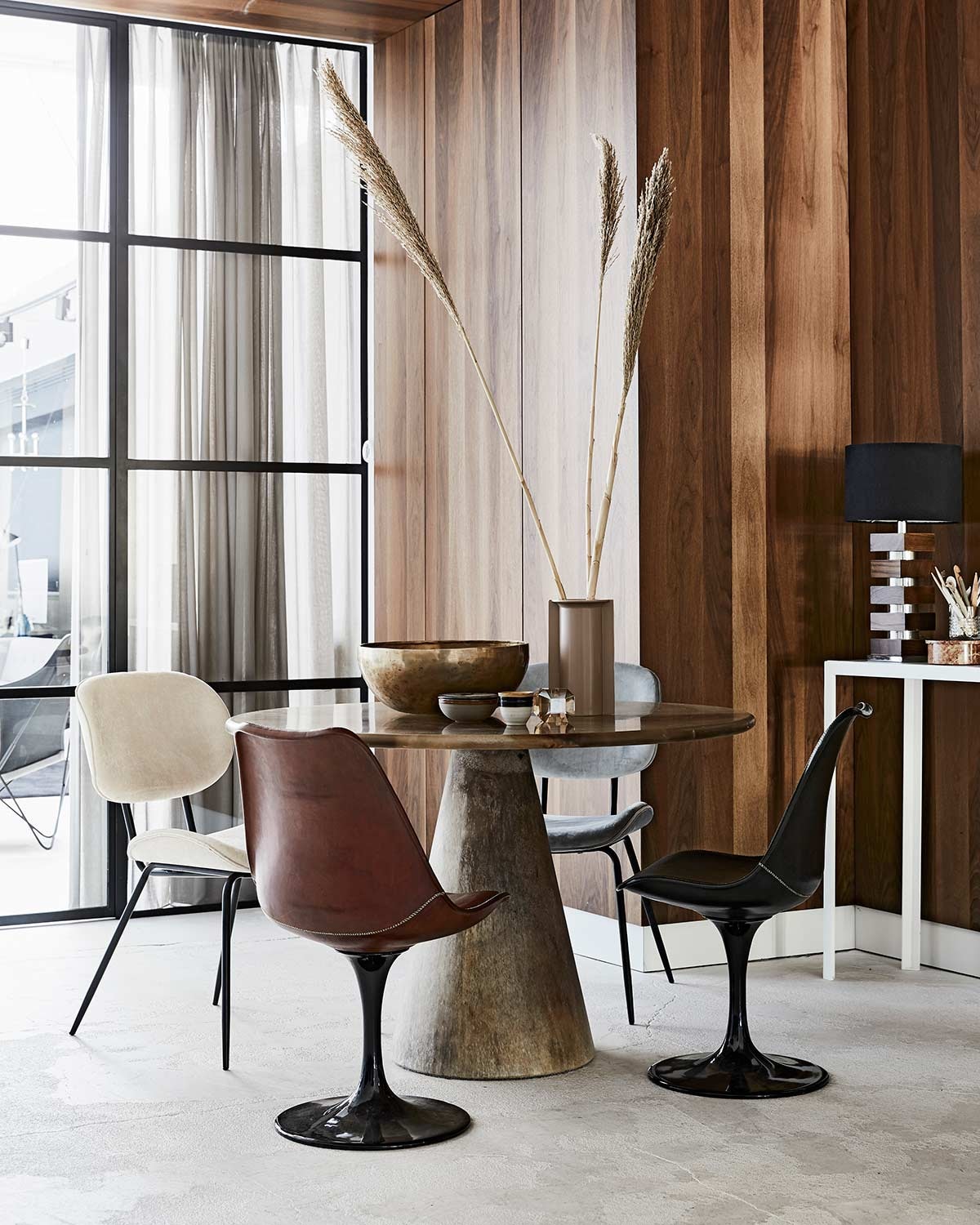 Wandbekleding en interieurontwerp door Sander van Eyck (). Ronde tafel Meltingpot in kleur goldstone (). Leren kuipstoelen (). Fluwelen stoelen, nudekleurige vaas, kopje, glazen kandelaar (). Bronzen schaal (). Vintage lamp en sidetable Consoletable Artemis by Sander van Eyck, prijzen op aanvraag, schaaltje met deksel (). Marmeren bakje met deksel ().