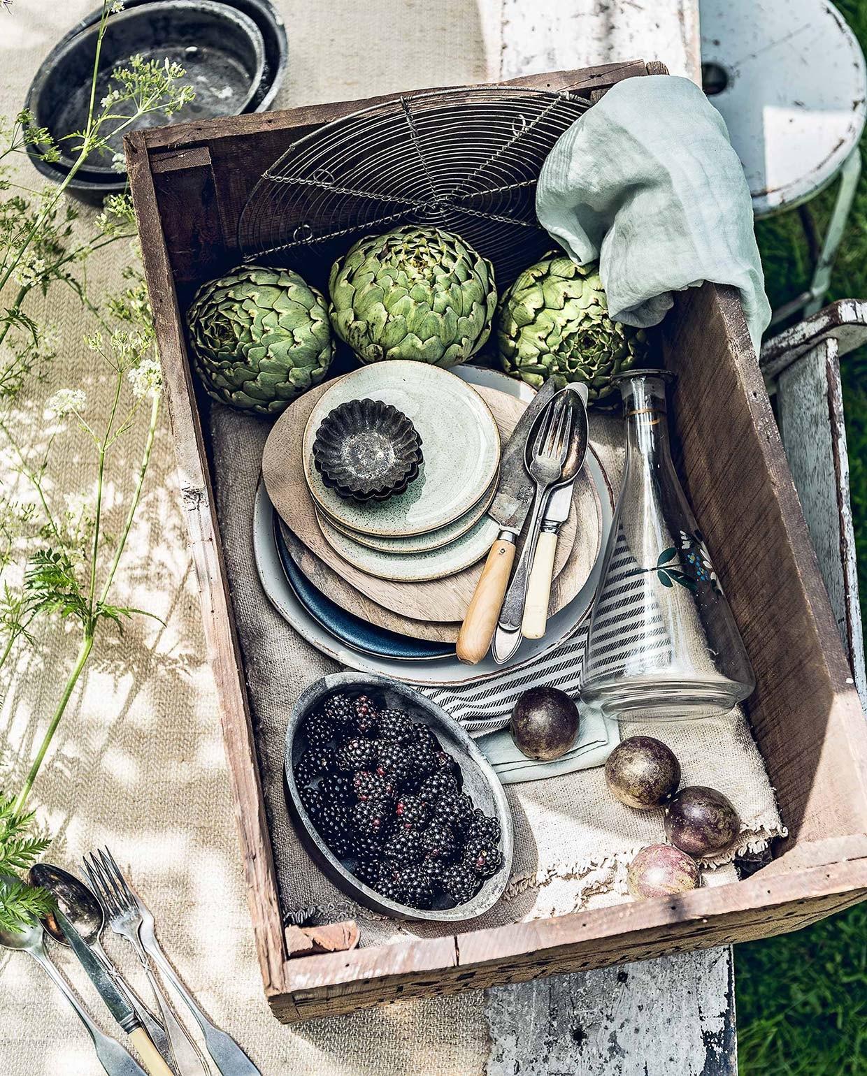 Oud linnen op rol, oude houten kist, opgevouwen tafelkleed van canvas (). Metalen schaaltjes, wit bord met ‘oud’ randje, zwart-wit gestreepte tafelloper, groene servetten, witte klapstoel (). Zachtgroene gebaksbordjes (). Mangohouten borden (). Karaf met bloemprint (). Witte metalen kruk (). Overig privébezit.