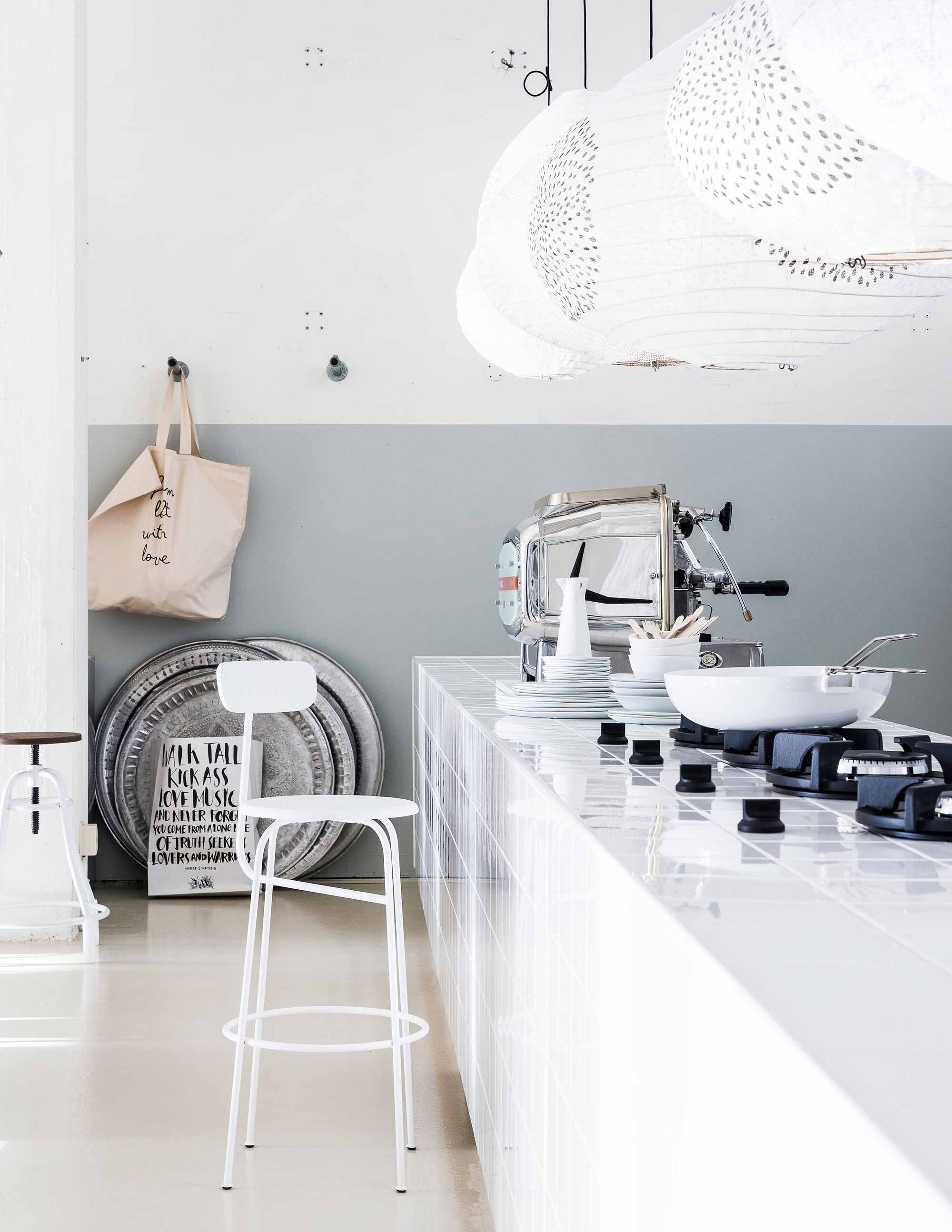 Grijze krijtverf op de muur, lampen van Paris au Mois d’Août, servies, papieren zak, tas van canvas, dienbladen (Loft). Barkruk met leuning van Menu, barkruk Malibu van La Forma (vtwonen.nl). Pan Abct, los handvat (Do’s). Industriële pitten (Pitt Cooking). Houten bestek (Dille &amp; Kamille). Espressoapparaat privébezit.