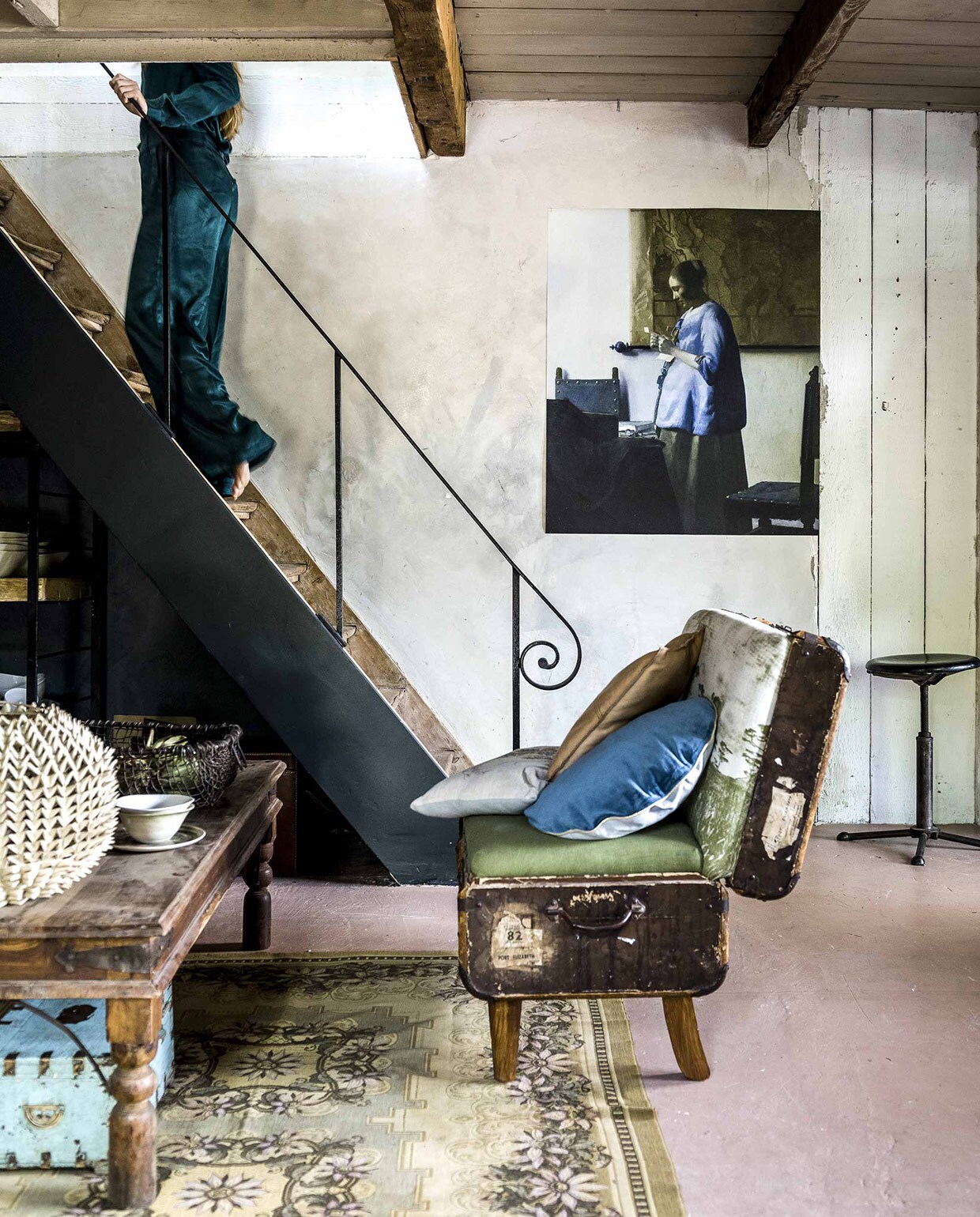 Zetel van een oude hutkoffer, gemaakt in Afrika, leren kussen, kommen op tafel (),  op zetel van Bloomingville, (vtwonen.nl), grijs kussen privébezit. Tafel (Jan van IJken), vloerkleed (). Lampenkap op tafel (). Mand van oude treinrails, kist onder tafel (). Kruk (), afdruk van Vermeers Brieflezende Vrouw uit de Rijksstudio op canvas (). Kleding (). Grijs kussen privébezit.
