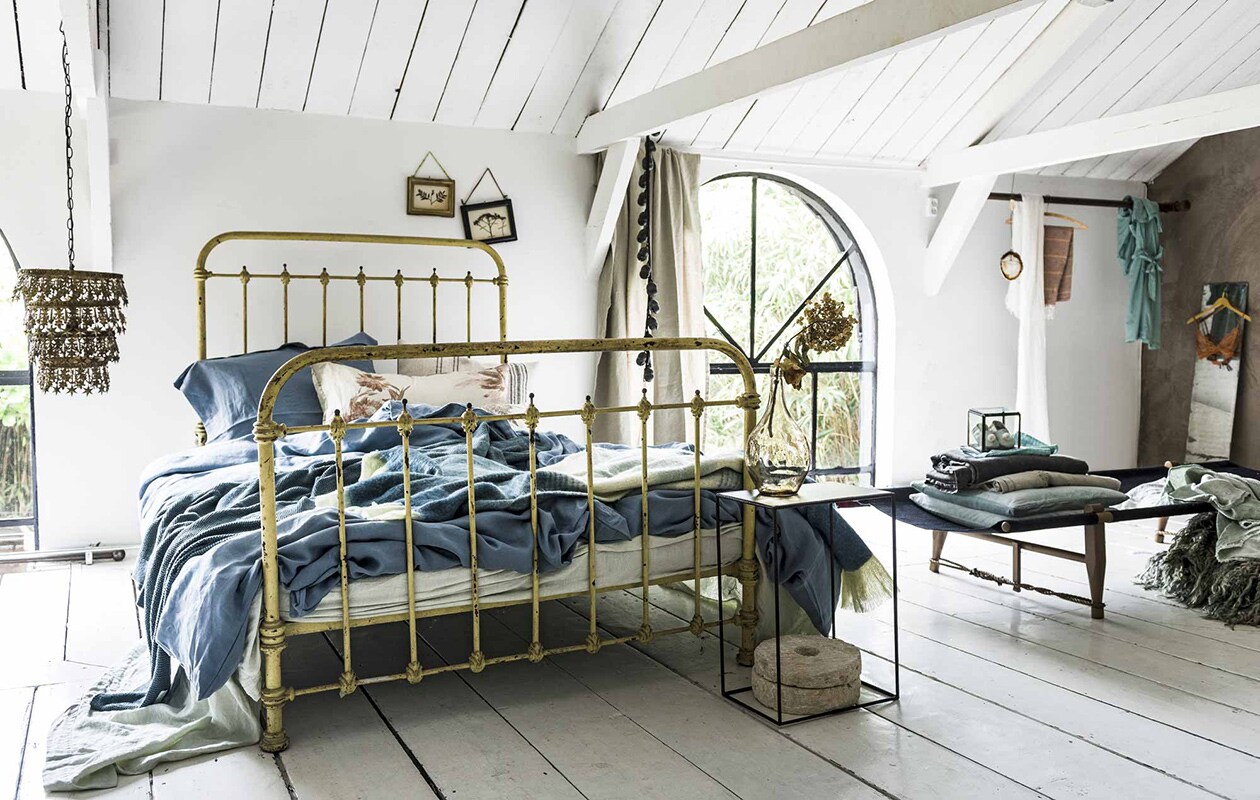 Hanglamp, laken van Society, kussen met bloemmotief, bellenkoord-, spijlenbed (), achter bed: lijstjes met gedroogde bloemen (). Linnen dekbedovertrekken in kleur old denim, bijpassend kussensloop, kelimkussen (). Zelfgemaakt kussen met bloemen van oude gordijnstof. Gestreepte plaid van Malagoon (). Grove plaid van gerecycled denim, zwart daybed van onbehandeld berkenhout, ongeverfd linnen en sisal (). Voor het bed: ijzeren bijzettafel (), vaas (), molenstenen privébezit. Op daybed: glazen kistje, babyslofjes van , stonewashed grijze plaid (), mintgroene kussens (), geborduurd laken, prijs op aanvraag (), andere stoffen privébezit. Opgevouwen kleed van schapenvacht, kunstwerk van steen en kristal (), jadegroene linnen plaid (). Linnen sjaal (), hammamdoek van linnen en bamboe (). Spiegel (kringloop), beha (), kimono (). Spiegel tweedehands.,