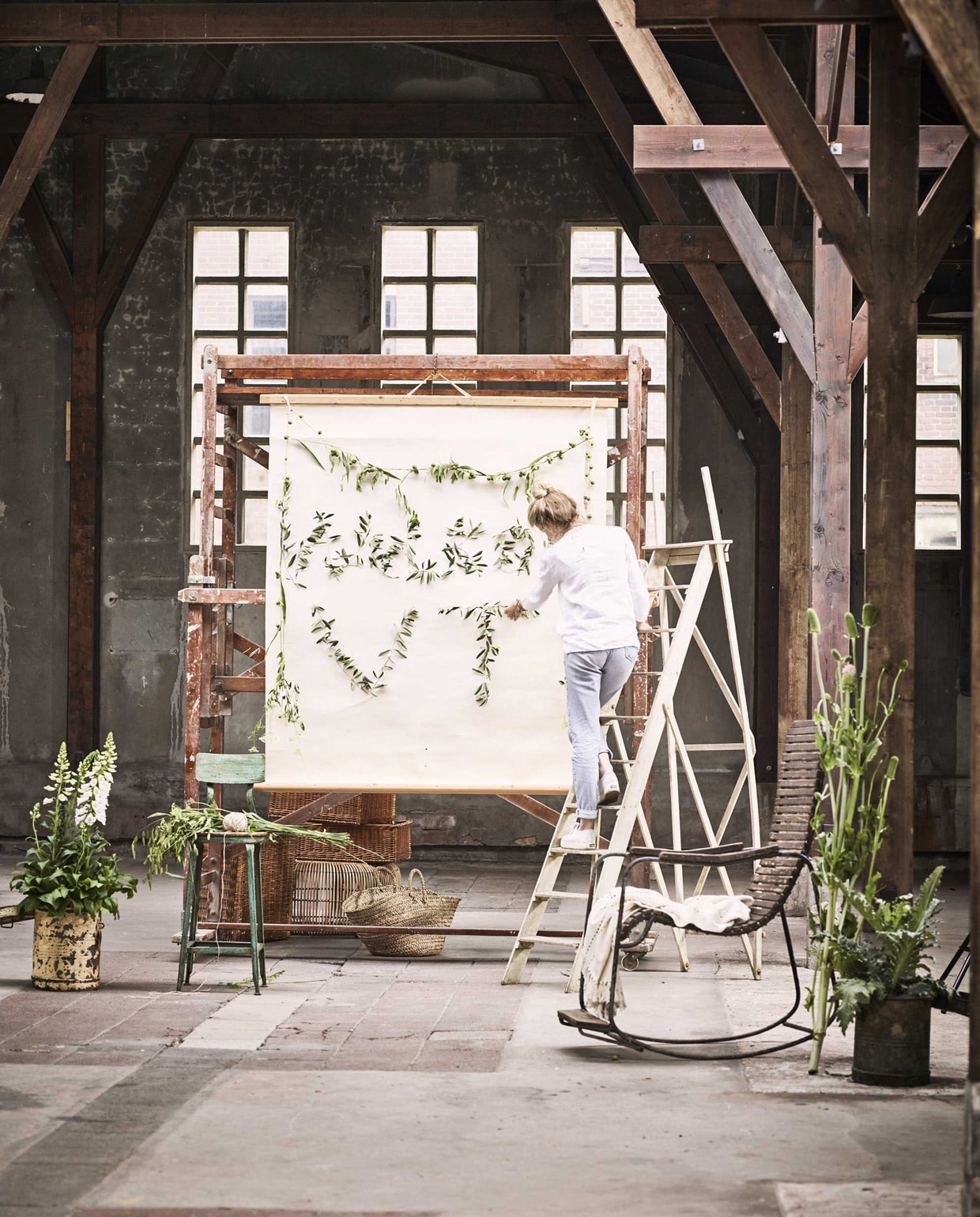 Papieren projectierol, rechthoekige rieten manden (), vintage trap (), stellage, schommelstoel (). Groene kruk, metalen bloempotten (). (Household Hardware),  (HK Living),  (vtwonen.nl).