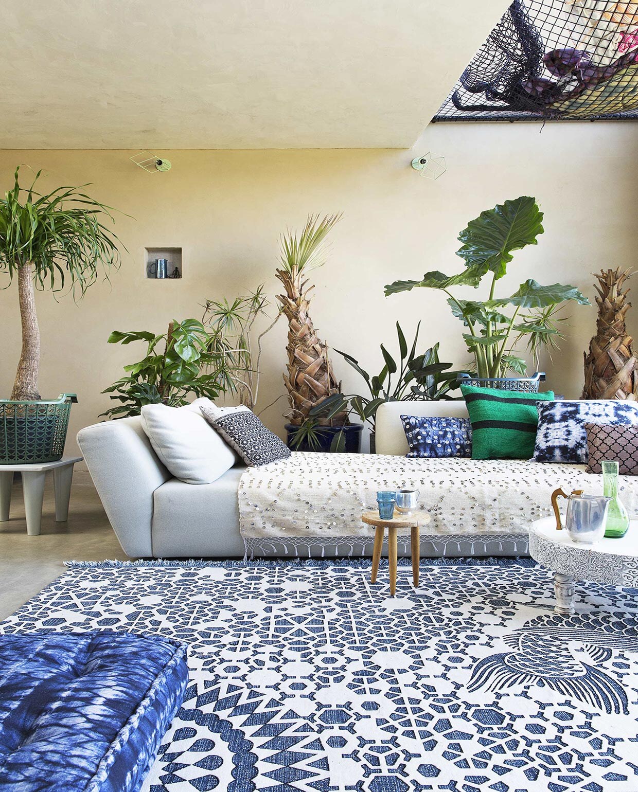 Zetel Ittaca in stof Divina, poef (Homestede). Ecru deken met lovertjes, groene karaf, blauwe beker, mand op tafeltje links, karaf in nis (Household Hardware). Kussens v.l.n.r. grijs metallic, zwart ecru Nightflower, Shibori Stripes Oblong (Zenza Home). Kussen groen-zwart gestreept (Household Hardware). Kussen Shibori Sta, kussen Femke Oblong (Zenza Home). Matraskussen op voorgrond Shibori Stripes, wit tafeltje Nomads (Zenza Home). Vloerkleed Milek (Design 020). Theepot (Neef Louis). Planten (www.chicplants.com). Overig privébezit.