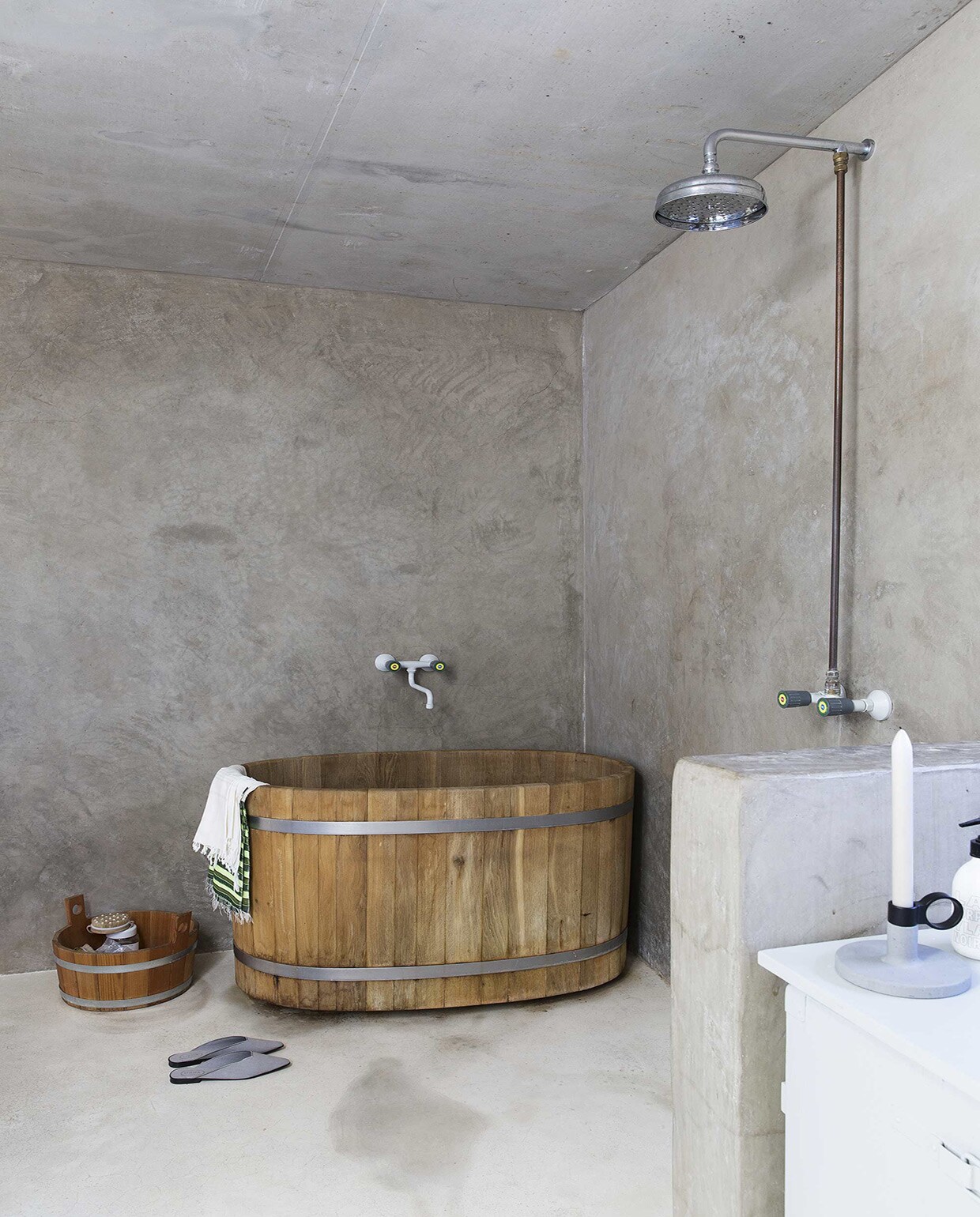 Japans houten bad Ofuro, prijs op aanvraag (badenvanhout.nl). Wanden van tadelakt en leemstuc van Tierrafino, wit marmeren terrazzo vloer (House of Bouw). Douchemengkraan, badmengkraan (FAR). Slofjes, kaarsenstandaard Concrete van Menu (Bed Habits). Kastje (Combitex). Overig privébezit.