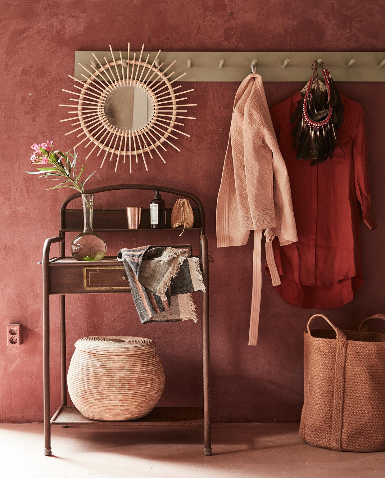 Terrakleurige mand, koperen beker (Six and Sons). Spiegel (L’Etoile Conceptstore). Verentooi, antiek metalen kastje, gastendoekje, flesvaas (Meker Wonen). Mand met deksel (Couleur Locale). Kapstok (Combitex). Zijden blouse, zalmroze jasje (Sissy-Boy).