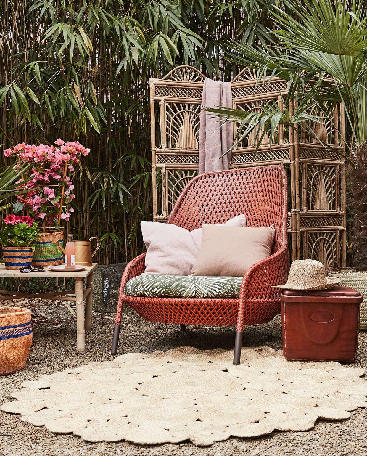 Kamerscherm (All the Luck in the World). Vloerkleed (Zenza). Loungestoel Ahnda van Dedon (Dacks). Bamboe salontafel (L’Etoile Conceptstore). Hoed, roze kussen (De Weldaad). Gieter, roze hamamdoek (Sissy-Boy). Linnen kussen (By Mölle). Groen met zalmkleurige mand, blauw gestreepte mand, grote zalmroze mand met blauw (Couleur Locale). Bord, leren koelbox (Meker Wonen).