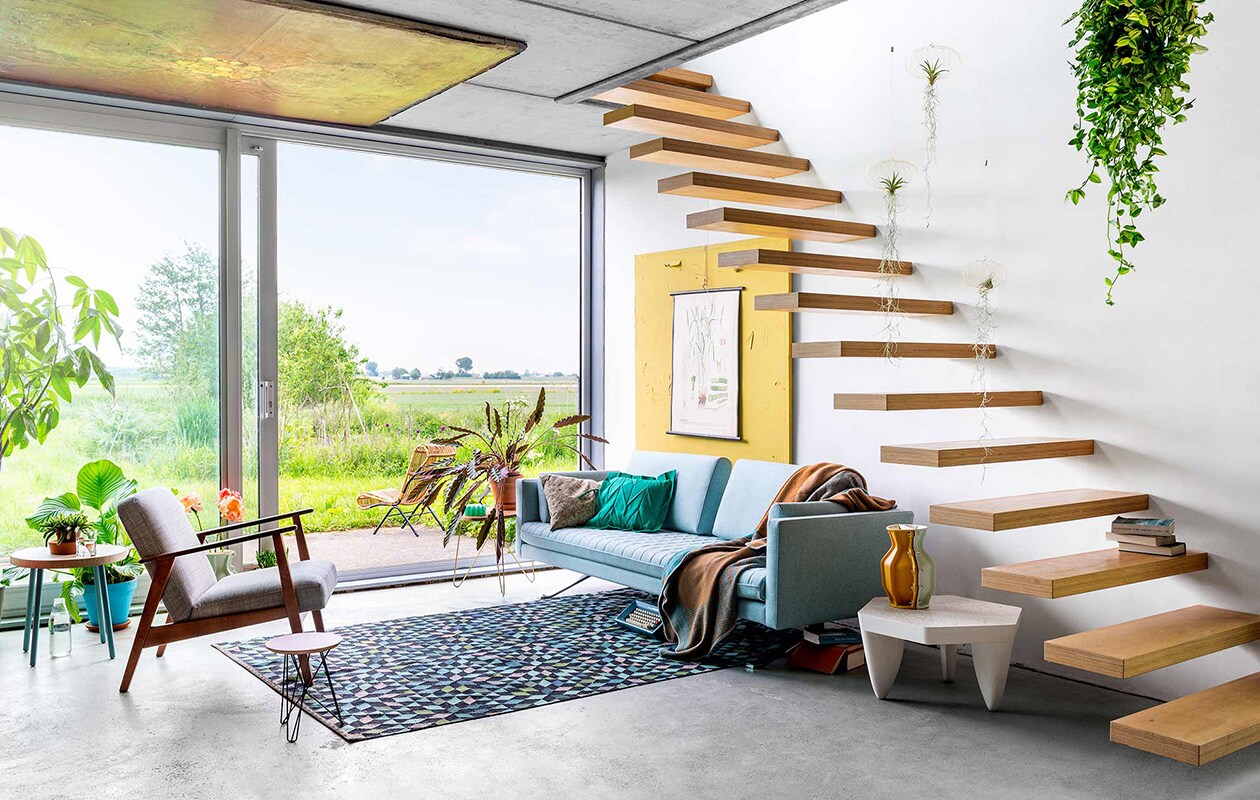 Poster Velence (). Hangplantjes Air Planting (). Bijzettafeltje L bij buitendeur (). Groen laag vaasje (). Vintage rotan stoel buiten (T). Zetel Kylian ontworpen door Edward van Vliet (). Licht kussen Kvadrat ().  Iittala x Issey Miyake collection (Iittala). Plaid Swell turquoise ().  ontworpen door Floris Hovers (Cor Unum). Bijzettafeltje Hexagon ontworpen door Roderick Vos (). Klein  ontworpen door Constant Nieuwenhuys (Spectrum). Vloerkleed Diamond Apple Green 55 ontworpen door Bertjan Pot ().  met blauwe poten (Studio Erwin Zwiers). Schildersdoek, stoel buiten, fauteuil privébezit.