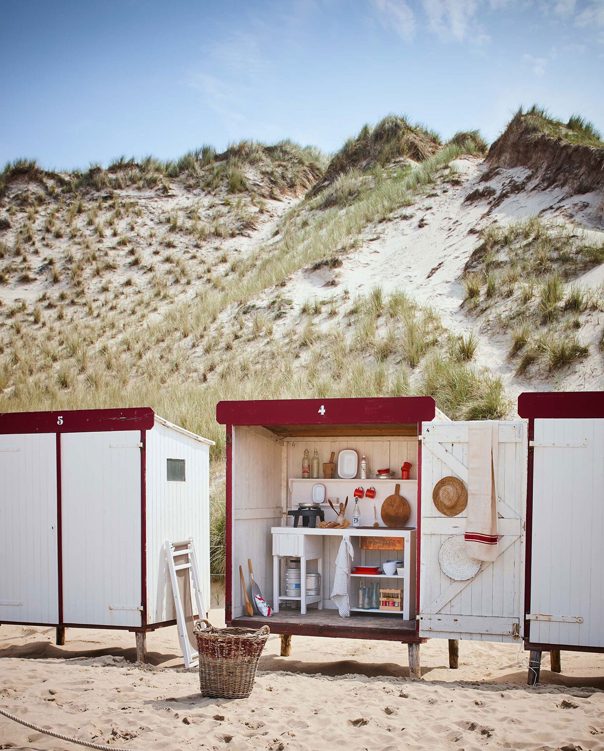 Keuken vanaf (). Bollenmand, strandstoel Alpina, emaillen bekers met oor, emaillen schalen set, grote rechthoekige emaillen schaal, emaillen kommen, kleine bekers, oude waterflessen (). Aluminium thermosfles, pannetjes (). Oude linnen lap met rode strepen (). Grote houten lepel, witte rieten schaal, houten vijzel, theedoek (). witte emaillen kommen (). Hoed (). Fles drinken van Nicolas Vahé (). Overig privébezit. Strandhuisjes te huur via .