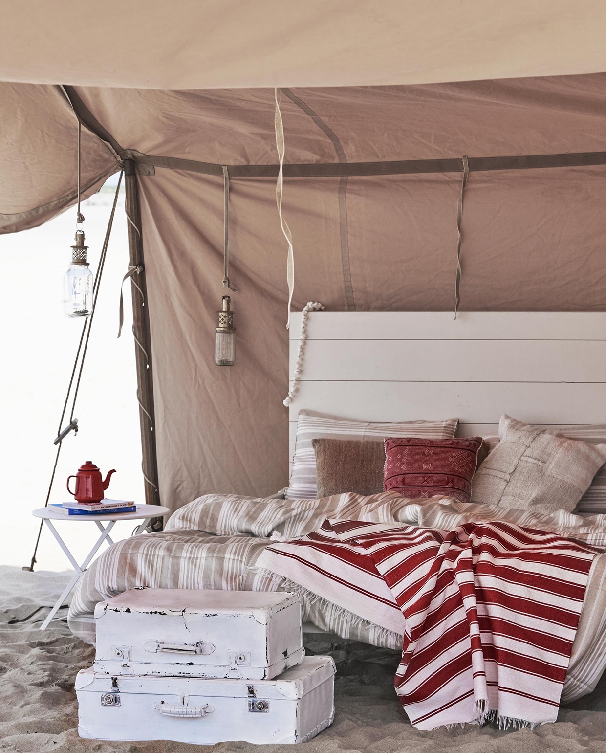 Houten bed (). Witte koffers (). Rood-witte doek vanaf ().  Tom Pouce van Fermob, emaillen theepot (). , vlaskleurig kussen (). Gestreept linnen dekbed-overtrek Sahara en kussenslopen Sahara (). Rood geborduurd kussentje (). Wit patchwork kussen ().