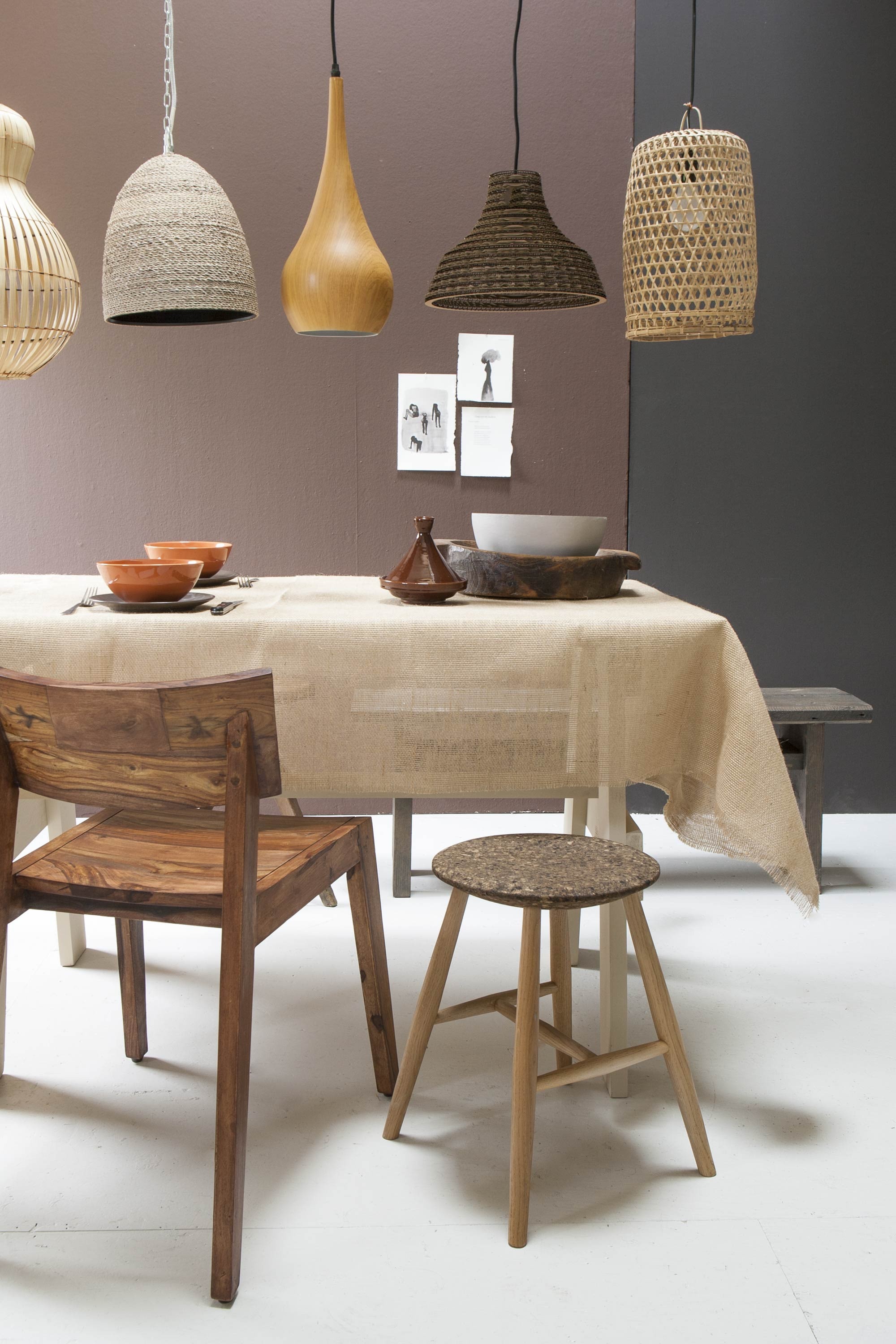 Muurverf links Spanish Brown nr. 32, rechts Chocolate Colour nr. 124 (Little Greene). Lampen, van links naar rechts: rotan lamp (Loods 5), lamp Cora van Lene Bjerre, houten lamp Would Cone van Zuiver, Graypants lamp van gerecycled karton (vtwonen.nl), rotan lamp (l’Etoile Conceptstore). Tafel op maat gemaakt, bankje, bruine houten schaal (Combitex). Houten stoel Bas van House Doctor (vtwonen.nl). Schaal, tajine (Loods 5). Schaal Färgrik, bordjes onderdeel van 24-delig servies Dinera (Ikea). Jute tafelkleed van de markt. Bestek en kruk privébezit.