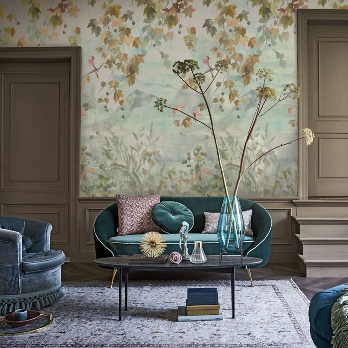 Groene bank met rond kussen Bold Monkey 165x79x77 cm, ronde poef, paarse kunstvorm, gouden waaier, zandloper, paarse ronde bak op bureau, blauwe vaas op pootjes, gouden sierbol Pols Potten, paars vierkant kussen, etui (loods5.nl). Staande lamp blauw met goud Bert Frank, groene bureaustoel Promemoria (covanderhorst.nl). Bureau, blauw boek, stolp met klossen (Edha-interieur.nl). Tafel zwart langwerpig (homestede.nl). Vloerkleed 305×177 cm (rozenkelim.nl). Blauwe stoel (pietjonker.nl). Gouden dienblad, vaasje glas met goudrand, lila langwerpig kussen (zarahome.com). Notitieboekje, plaid (maisonnl.nl). Doosjes onder de tafel en op trap, paarse schaal (bungalow.dk). Blauwe vogel (harlequin-lisse.biz). Blauwe mok (hm.com). Behang Miyako 140×300 cm (wva.nl). Vloer vtwonen Novilon Zoethout, 400 cm breed, Blauwe kwal Leonardo 11x7cm (vtwonen.nl). Goudkleurige schoenen privébezit. vtwonen 10-2019 | Styling Liza Wassenaar | Fotografie Alexander van Berge