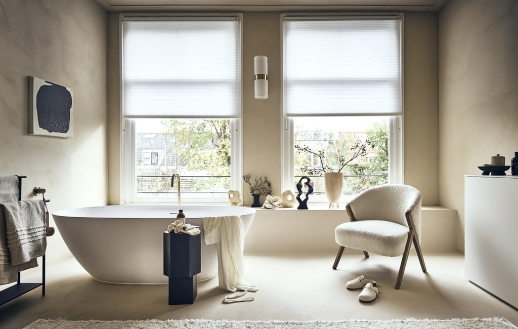 Witte stoel met houten poten en badstof bekleding € 299,-, badmat op rek € 19,99, handcrème € 15,99, vloerkleed € 219,-, sloffen € 25,99, beige bakje met deksel € 17,99, ochtendjas € 69,99, scrubhandschoen op zwart kastje prijs op aanvraag (zarahome.com). Zwart rek van Ferm Living € 189,- (vtwonen.be). Beige plaid € 99,-, vaasje met rond gat links € 54,95, beige vaas in het midden € 57,95, zwarte siervorm € 79,95, grote beige vaas € 89,95, borstel €15,95 (eijerkamp.nl). Kunstwerk aan wand, prijs op aanvraag (@ansdekruyf). Papieren kunstwerk € 150,- (elsavisser.com). Zeep in fles € 18,-, losse zeep € 22,-, zeepfles op zwarte kruk, prijs op aanvraag (sukha.nl).  Zwarte natuurvorm € 35,- (taxidermy.nl). Zwarte schaal op drie poten € 19,99 (hm.com). Zwarte kruk € 249,- (aedamanthony.nl). Muurverf onbekend. Overig privébezit. vtwonen 1-2023 | styling liza wassenaar | fotografie sjoerd eickmans