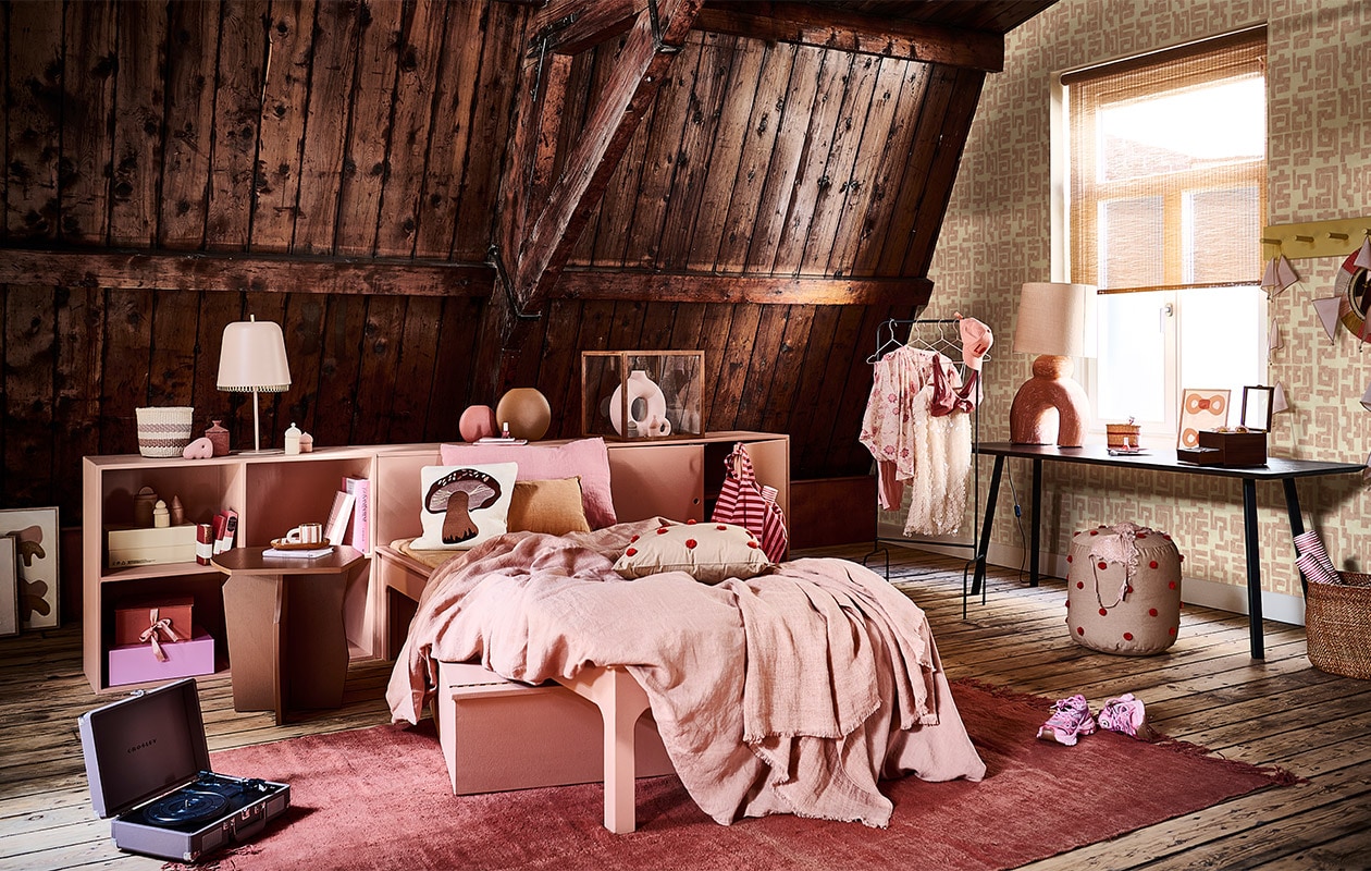 Donkerbruin bureau New Classic Home Desk, 100x60x75 cm (lxbxh) € 1424,-, donkerbruine bijzettafel Scissors Coffee Table 50, 50 cm (Ø) € 429,- (studio-henk.nl). Roze kast, roze bed, gele wandkapstok en roze box onder bed prijs op aanvraag via Combitex (com-anders). Behang TP-329-02 van Élitis, per rol van 70 cm x 10 m € 196,- (loggerewilpower.com). Linnen dekbedovertrek € 350,-, rozerood vintage hennep vloerkleed uit Turkije, 255×177 cm € 990,-, roze linnen kussensloop Lychee € 43,-, gevlochten sisal mand op kast € 32,-, gevlochten mand op de vloer Iringa € 89,-, roze vlaggen aan kapstok Numero 74 € 16,-, roze plaid op bed Margaux Almond € 169,- (couleurlocale.eu). Poef Dot Tufted van Ferm Living € 105,-, houten vitrinekast Miru van Ferm Living € 269,-, kussen Forest Porcini van Ferm Living € 59,-, kussen Dot Tufted van Ferm Living € 59,-, aardewerken potje met geurkaars Ura van Ferm Living € 35,- (vtwonen.nl). Platenspeler Crosley Cruiser DeLuxe in kleur Purple Ash € 90,-, mok en ovaal bord op nachtkastje Milu Snack Set € 45,- (wonenmetlef). Roze nachtlamp op kast € 99,-, roze notitieboeken in kast vanaf € 11,95, pet met print Love € 45,-, blouse met bloemenprint Love Stories € 135,-, zonnebril met bloemenprint in bakje op tafel € 30,-, bh op poef € 70,- (maisonnl.com). Kunstwerk linksonder in hoek, klein kunstwerk linksonder vooraan en kunstwerk in raam prijs op aanvraag (anneoldekalter.com). Sneakers Axel Arigato € 270,-, knalroze doos in kast van Hay € 18,-, kleine roze siervorm links op kast voor mand Hay € 8,-, roze boek op nachtkastje € 17,50 (debijenkorf.nl). Boek in kast Yves Saint Laurent € 69,99, boek Wonderland € 79,99, nagellak op kast en op tafel per stuk € 4,99, make-upkwast op tafel set van 5 € 9,99, ronde vaas in stolp € 29,99, kleine vaas in stolp € 4,99, witte glitterjurk aan rek € 34,99, schotel met bloemvorm op tafel € 7,99, roze broek aan kledingrek € 14,99, bruin potje met rond deksel op gele schoenendoos € 9,99, bh aan rek € 9,99, gestreepte tas € 19,99 (hm.com). Diverse blokken Old City Blocks verdeeld in en op kast € 60,-, zwart metalen kledingrek € 90,-, spiegel aan wandkapstok € 65,- (thearchivestore.com). Rollen rood met wit papier per set van 3 € 7,99, rood gestreept notitieboek op kast € 5,99, box met strik € 14,99 (sissy-boy.com). Bruine ronde vaas € 59,- roze ronde vaas € 32,50,- (festamsterdam.com). Oranje langwerpig kussen € 15,99, bruine houten sieradenbox € 49,99 (zarahome.com). Lamp met oranje voet € 499,- (lanena-home.com). Roze kledinghangers per stuk € 1,33 (sostrenegrene.com). Raambekleding privébezit.