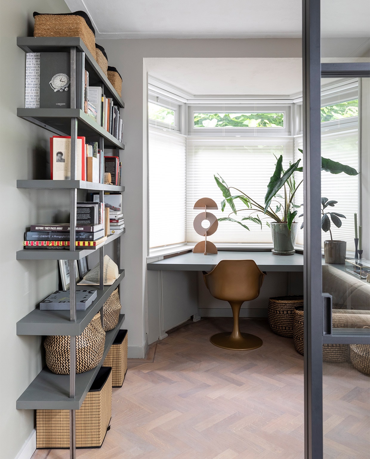 Bij de boekenkast Flexa Creations muurverf Camouflage Green, rechts op de muur Worthy Clay, boekenplank en bureau Flexa Strak in de Lak lak Woudgroen (flexa). Boekenkast en bureau op maat gemaakt, prijs op aanvraag (remmers-design). Deuren van zwart gecoat aluminium, prijs op aanvraag (gewoongers.nl). Armstoel Tulip van Household Hardware € 365,- (eijerkamp). Zeegras manden op de vloer onder bureau van Bloomingville € 125,-, manden op de kast van Compactor vanaf € 17,35, manden in de kast van Compactor € 25,99, kandelaars Metal Black van vtwonen € 19,95, tafellamp Luminous Circle van HKliving € 157,- (vtwonen.be). Spiegels vanaf € 19,50 (weldaad.com). Manden onder de kast niet meer verkrijgbaar (ikea). Overig privébezit. 8 Flexa Strak in de Lak lak &amp; Flexa Easycare Muren muurverf Saliegroen. Gordijnen Lill, per 2 € 3,99 (ikea). Vloerlamp Philine van Lucide € 149,95 (vtwonen.be). Kunstwerken boven de haard gemaakt door Marlies Hoevers, prijs op aanvraag (hoeversid.com). Elementenbank Vint van HKliving vanaf € 2074,-, vloerkleed Afghano van Eijerkamp Collectie € 3078,-, plaid € 59,95 (eijerkamp.nl).