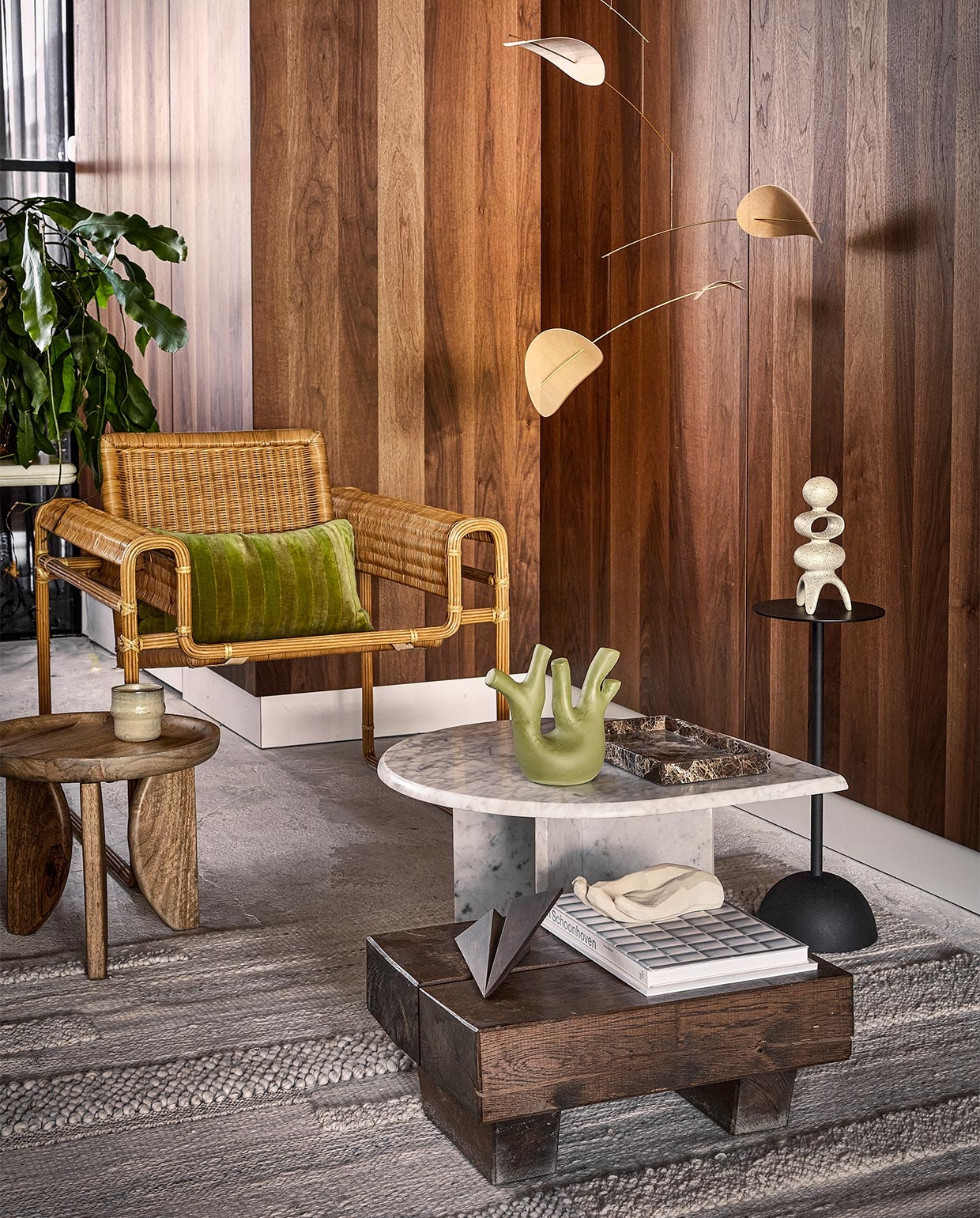 Muurpanelen met walnoothoutfineer prijs op aanvraag (cocoon-living.nl). Vintage wickerstoel in Wassily Chair-stijl € 2950,-, vintage salontafel van Carrara-marmer € 875,-, marmeren dienblad € 98,-, lage tafel van antieke spoorbielzen, set van 2 € 550,- (cocooncollectables.nl). Mangohouten bijzettafel High Heels, set van 2 € 249,- (vtwonen.be). Mok Nara, set van 4 € 26,95 (loods5.nl). Groene ecomix sculptuur Tree € 39,95, matzwarte, aluminium bijzettafel € 59,95, beige ecomix sculptuur Space € 39,95 (urbannatureculture.com). Betonzandstenen hand Bless van Cooee X Kristiina € 72,50, eikenhouten vliegtuig Maverick Plane van Boyhood € 59,50, houten mobiel Drifting Clouds van Flensted, 70×100 cm € 135,- (deensedingen.nl). Vloerkleed Brönden, 170×240 cm € 349,- (ikea.nl). Boek privébezit.