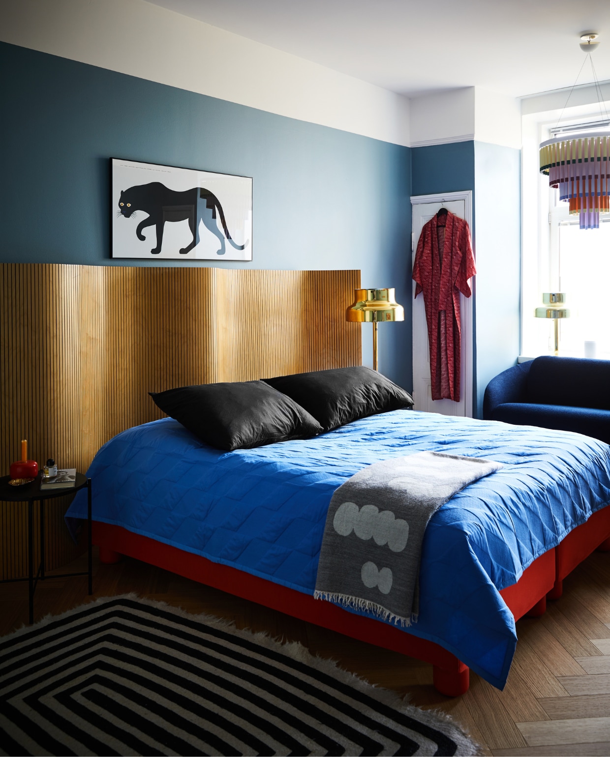 Het hoofdbord is een vintage kamerscherm van Martela. Bedbekleding en poten, bank Jumbo en Kroonluchter Cocktail Hakola. Sprei Kite Quilt Hay. Poster Pantera van Enzo Mari voor Danese Milano. Vintage vloerlampen Bumling Ateljé Lyktan.