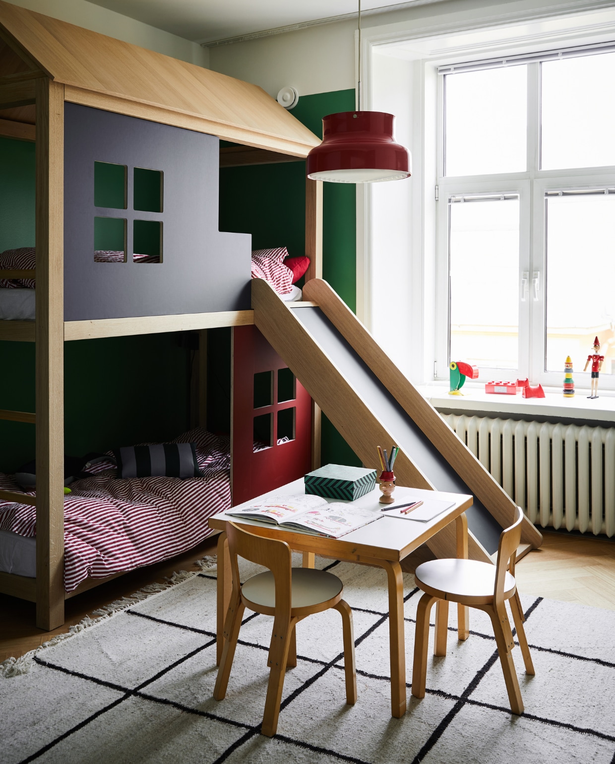 De jongens delen een kamer én een stapelbed-huis, gemaakt door timmerman en meubelmaker Juhan Mikone. De tafel en stoelen van Artek komen uit Annaleena’s ouderlijk huis. Vintage lamp Bumling Ateljé Lyktan.