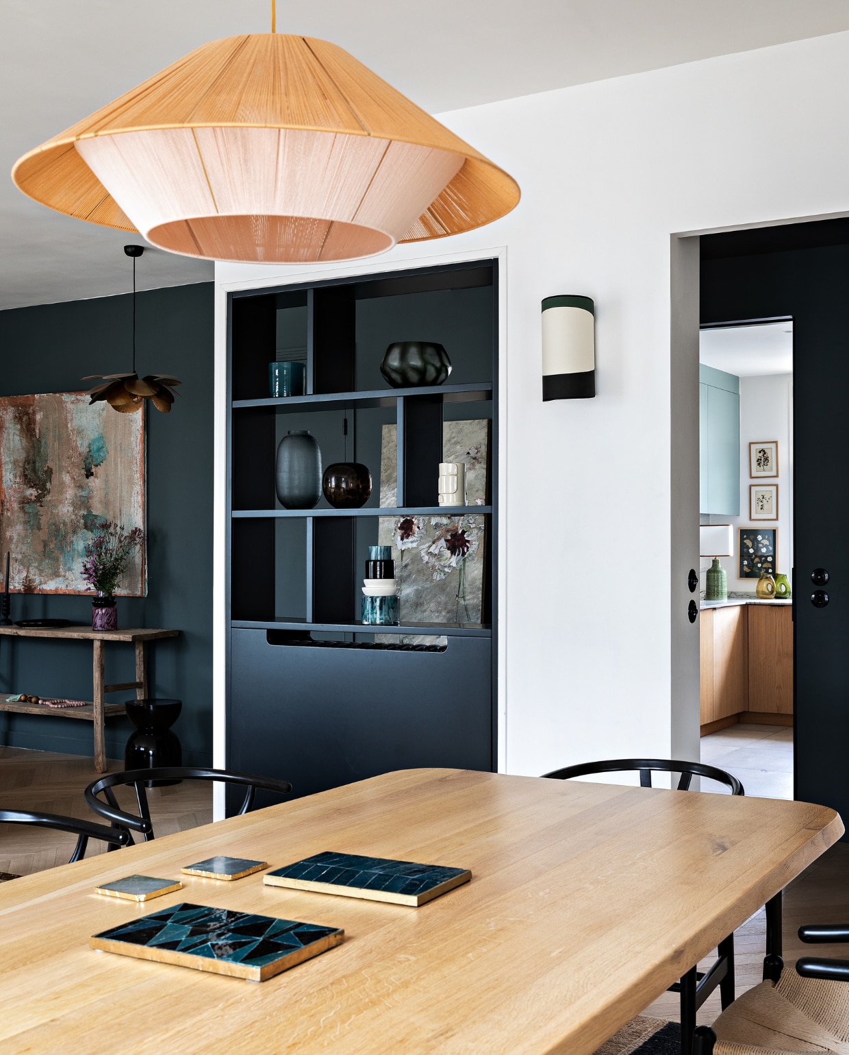 Eiken tafel Oasis en wandlamp Maison Sarah Lavoine. Stoelen Carl Hansen &amp; Søn. Hanglamp Maison Paloma. Open vakkenkast maatwerk. vtwonen 12-2022 | styling Marie-Maud Levron | fotografie Yann Deret | tekst Anne-Catherine Scoffoni | tekstbewerking Christine van der Hoff