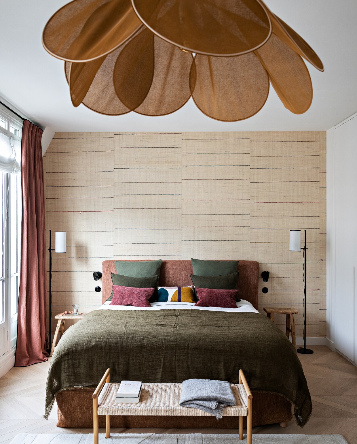 Hoofdeinde, plaid, velours kussens en gordijnen Maison de Vacances. Grafisch kussen La Redoute. Raffia wandpanelen Tsarabanjina van Elitis. Vloerlampen Caravane. Bijzettafels La Maison Pigalle. Bank Zara Home. Hanglamp George. Kleine leeslampen DCW éditions. Vloerkleed Toulemonde Bochart. Overig onbekend. vtwonen 12-2022 | styling Marie-Maud Levron | fotografie Yann Deret | tekst Anne-Catherine Scoffoni | tekstbewerking Christine van der Hoff