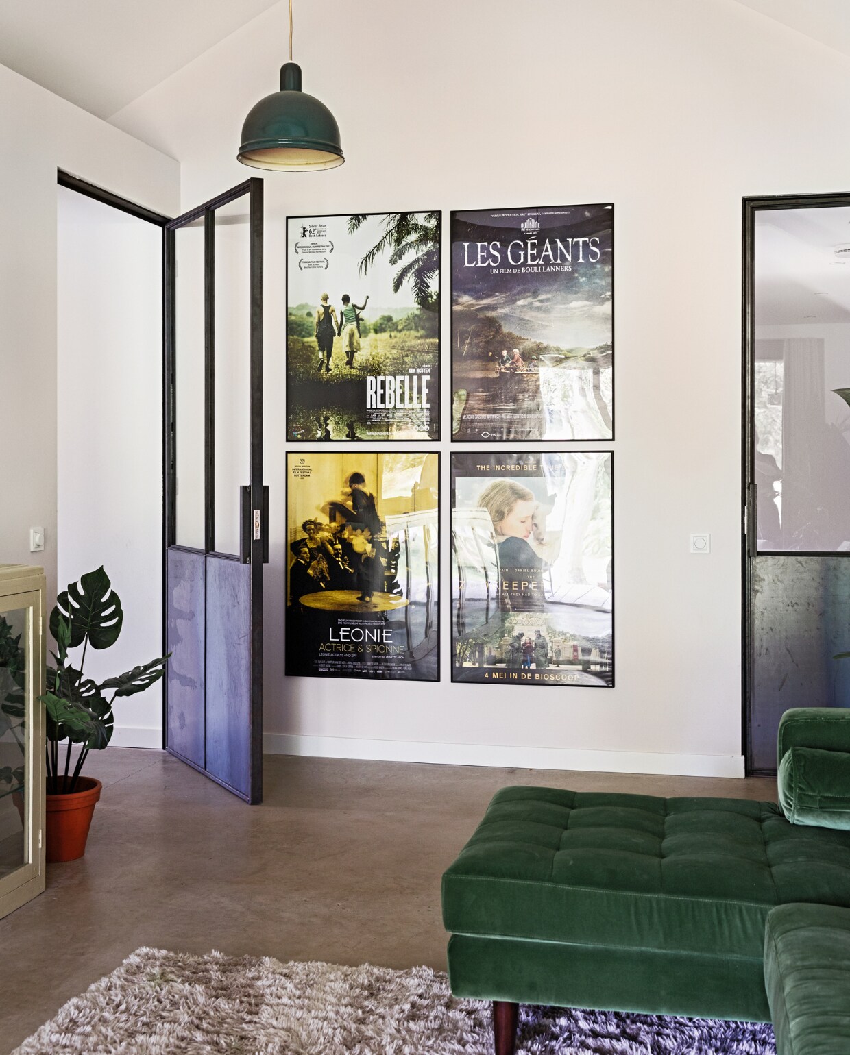 Muurkleur Luxurious Silk van Flexa Creations, vloer gevlinderd beton van Bull beton, bank Scott van Made, hanglamp vintage, stalen deur Gillissen Ontwerp, nepplant The Goodstore, pot Intratuin, lijsten Poster Store, posters Marktplaats, kast Burbri Antiek, kleed Karwei.