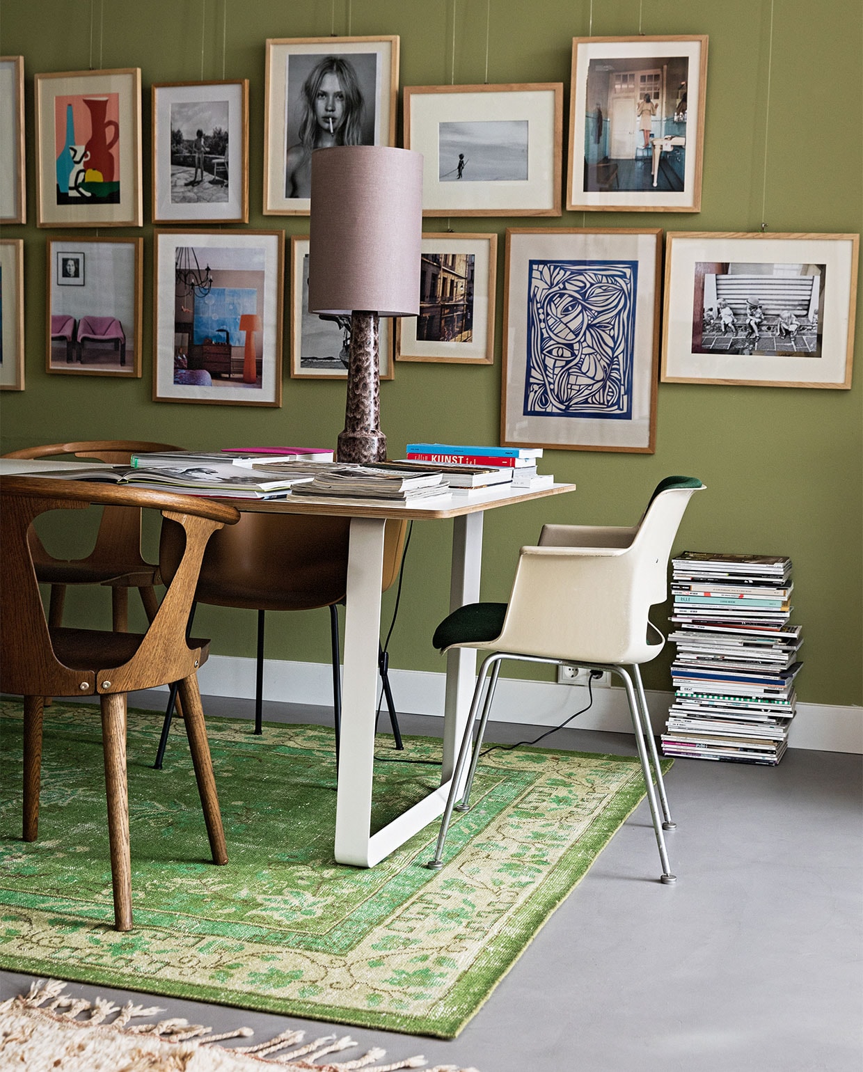 Tafel 70/70 Muuto. Stoelen mix van Fiber Tube Oker en Fiber Wood Dusty Green van Muuto, In Between SK1 Gerookt van &amp;Tradition en vintage Cordemyer van Gispen (groene bekleding) via Best Wel Hip. Schemerlamp en kleed HKliving. Wandverf Boxington van Little Greene. Vloer beton. Kunst eigen verzameling.