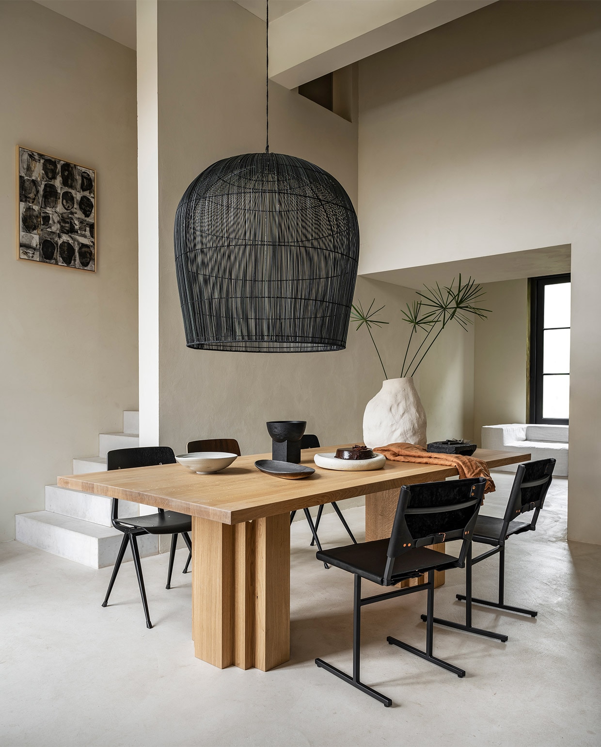 Eikenhouten tafel Brut van Aad Bos, 240x110x75 cm (lxbxh) € 4300,- (mokkoamsterdam.com). Rieten lamp van Ay IIluminate, 95 cm (h) € 1750,-, stoelen Result van Hay € 269,-, vaas Vulca van Ferm Living € 199,- (vtwonen.be). Stoelen van staal en leer € 490,- (wdstck.eu). Handgemaakte schalen in verschillende vormen vanaf € 75,- (marjokedeheer.com). Houten schaal op voet € 49,95 (urbannatureculture.com). Schilderij van Marlies Hoevers, prijs op aanvraag (hoeversid.com). Bank met linnen hoes, zijkant 120x120x60 cm (lxbxh), tussen-stuk 120x90x60 cm (lxbxh), verkrijgbaar december ’21, per element vanaf € 850,- (10dayslifestyle.nl).