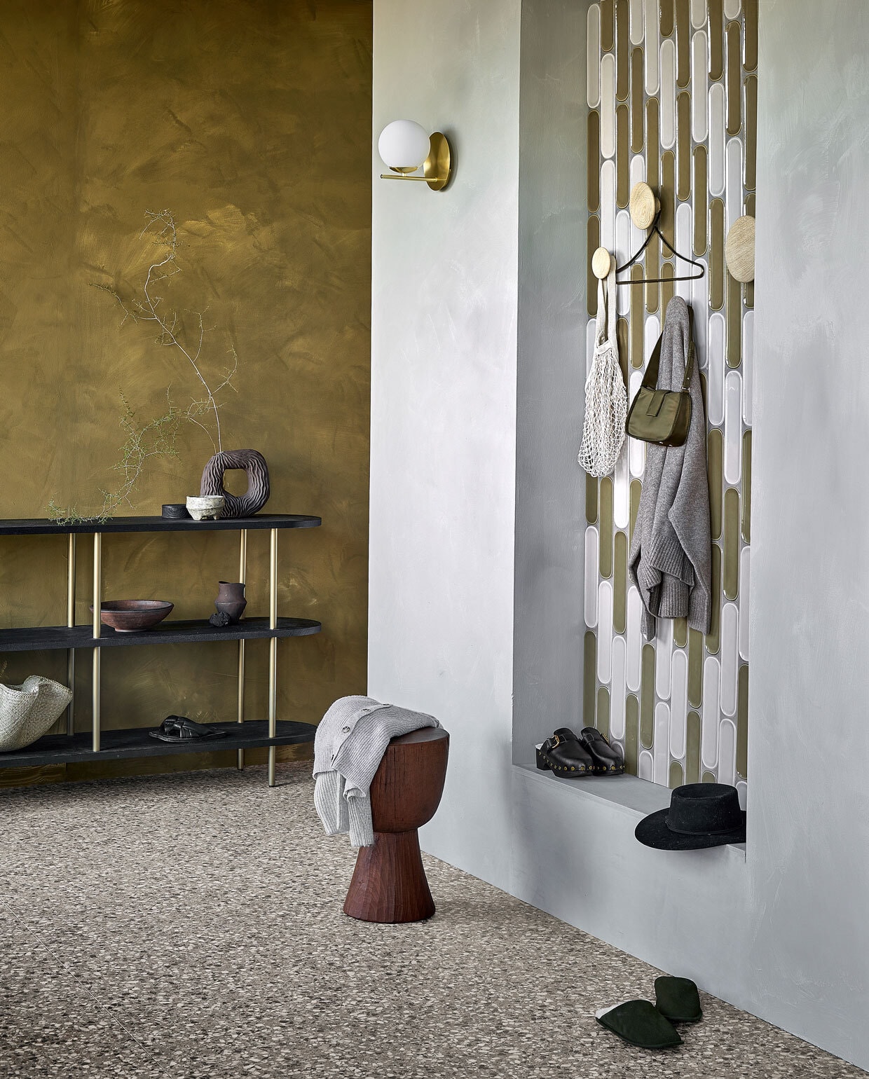 Wandtegels Shapes Greige Round glans, 7,5x30 cm per m² € 68,99, wandtegels Shapes Olive Round glans, 7,5x30 cm per m² € 68,99, vloertegels Terrazzo Clay Flakes, 90x90 cm per m² € 78,-.M.m.v. vestingh.nl (muurverf Lab Paint in Mist, muurverf achterwand Lab Paint in Hunter), loods5.nl (kast), polspotten.nl (houten kruk Tam Tam), vtwonen.be (wandlamp van Trio, wandhaken van Muuto), hm.com (aardewerken ronde vaas, ronde houten doos, rieten schaal), zarahome.com (bruine vaas, sloffen, messing kledinghanger), zara.com (tas, hoed), mango.com (zwarte klompen). Overig privébezit. vtwonen 02 2023 | productie Tanja Saarberg | styling Sanne Ketelaar | fotografie Peggy Janssen