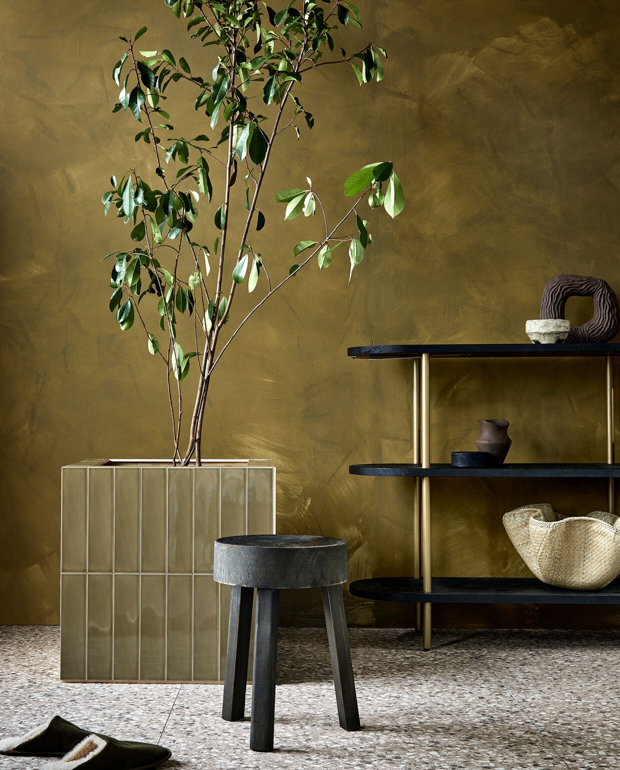 Vloertegels Terrazzo Clay Flakes, 90x90 cm per m² € 78,-, wandtegels op plantenbak Shapes Olive glans, 7,5x30 cm per m² € 58,99. M.m.v. vestingh.nl (muurverf Lab Paint in Hunter), loods5.nl (kast), basiclabel.nl (houten kruk), hm.com (aardewerken ronde vaas, rond houten doosje, rieten schaal), zarahome.com (bruine vaas, sloffen). Overig privébezit. vtwonen 02 2023 | productie Tanja Saarberg | styling Sanne Ketelaar | fotografie Peggy Janssen