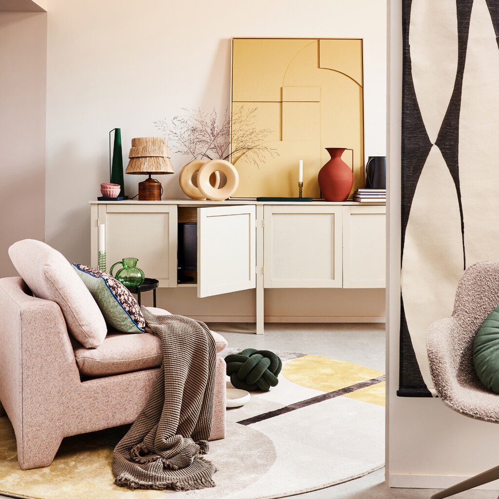 Kast op maat gemaakt, prijs op aanvraag (combitex.nl). Bruin gebloemd kussen by Doris voor HKliving op fauteuil, 35x60 cm € 37,95, boucléstoffen retro loungefauteuil € 949,-, zwart-wit abstracte wandkaart, 97x157 cm (bxh) € 49,95, groene glazen karaf, 16 cm (Ø) € 29,95, okergele en groene glazen kandelaars, per stuk € 17,95, zandkleurig reliëfpaneel ingelijst, 63x83 cm € 469,-, crèmekleurige ronde vazen van HKliving, per stuk € 34,95 (hkliving.nl). Katoenen plaid 130x170 cm € 45,99 (zarahome.com). Vloerkleed Hilton, 240 cm (Ø) € 465,-, taupekleurige armstoel Albert Kuip Swivel € 269,-, tray € 49,- (zuiver.nl). Groen kussen Knot van Design House Stockholm, 30 cm (Ø) € 115,90, zwarte kan van vtwonen € 18,-, bruine vaas van Pols Potten, onderdeel van set van 3 € 220,- (vtwonen.be). Tafellamp € 119,50 (maisonnl.com). Overig privébezit. vtwonen 02-2022 | styling Esther Jostmeijer | fotografie Bart Brussee
