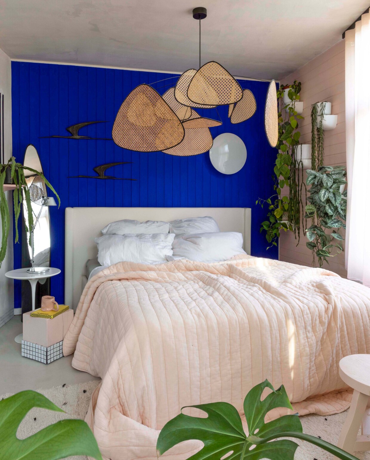 Muurverf Ultra Blue Little Greene. Wandvogels vintage. Witte bijzettafel Tulip Knoll. Roze bijzettafel zelfgemaakt. Kruk zelfgemaakt. Roze mok Siup Studio. Vintage spiegel Lipstick Roger Lecal. Ronde wandlamp Eklipta Louis Poulsen. Hanglamp Screen Market Set. Sprei Crisp Sheets. vtwonen binnenkijken special 121-2022 | productie, fotografie &amp; tekst Anne Catherine Scoffoni | tekstbewerking Caroline Westdijk