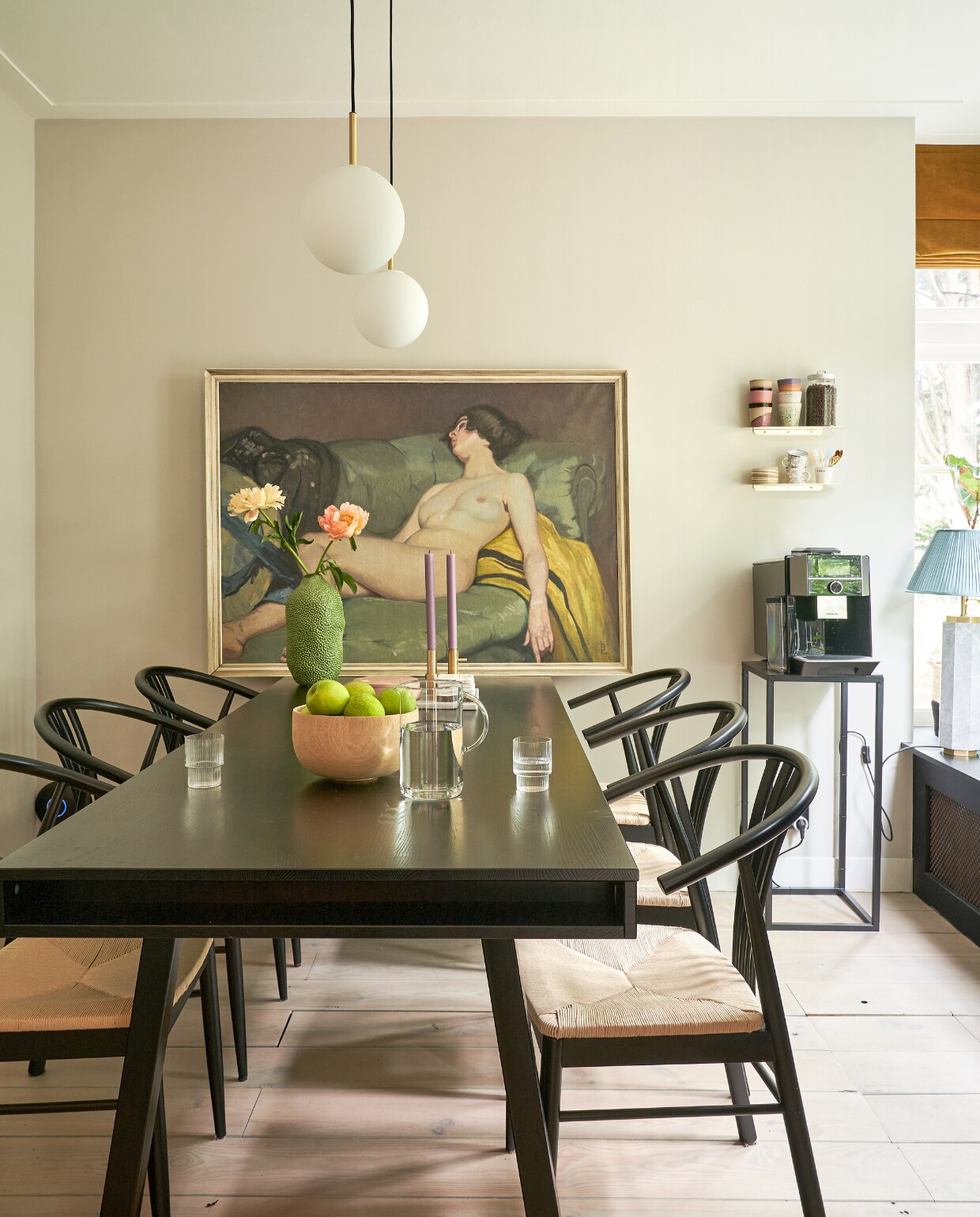 Muurverf Champignon van Gamma, eettafel Trian van Woood Exclusive, kandelaars Fritz Hansen, roze schaal Monday is a state of mind, vaas Jotex, glazen Ferm Living, stoelen fonq, hanglamp Tr Bulb van Menu, schilderij komt uit de familie, wandplankjes Nordal, koppen Atelier van Schaijck en HKliving, zwarte bijzettafel Intratuin, tafellamp Eichholtz, overig onbekend. vtwonen 02-2023 | productie CocoFeatures.com | fotografie Muk van Lil | tekst Caroline Westdijk