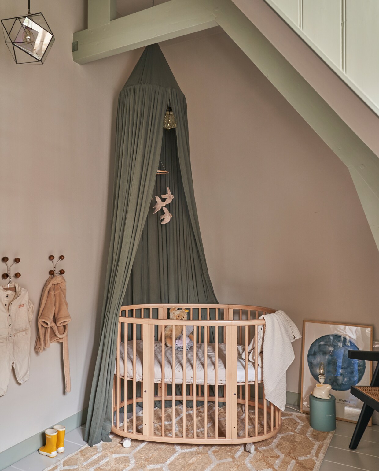 Verfkleur balken Blue Gray, verfkleur muur Skimming Stone, beide Farrow &amp; Ball. Ledikant Stokke, groene hemel Konges Sløjd, beddengoed Garbo &amp; Friends, vilten mobiel Nanami, houten kapstokjes H&amp;M Home, hanglamp vintage, konijnenlamp komt uit Emilie’s kinderkamer, print sterrenhemel boven Amsterdam op het moment van de geboorte van Beer van MrStarsky, vloerkleed Westwing, stoel Woood. vtwonen 02-2023 | productie CocoFeatures.com | fotografie Muk van Lil | tekst Caroline Westdijk