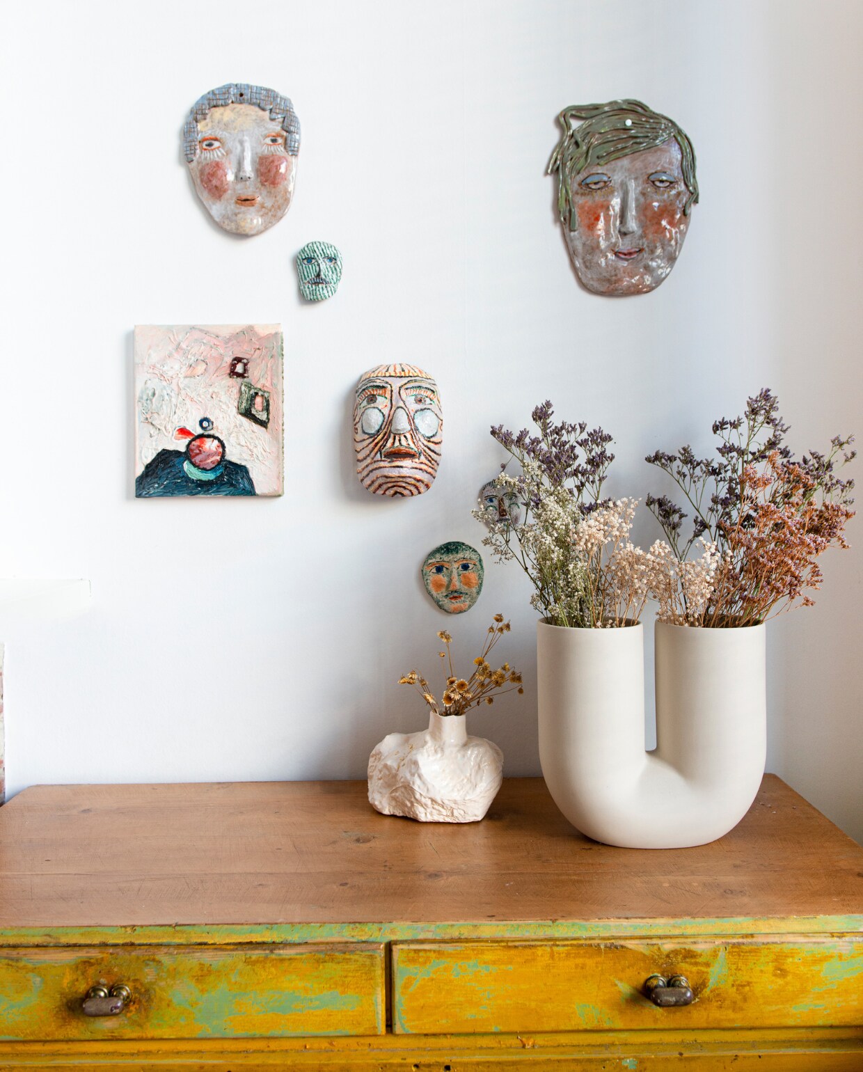 Keramische maskers Choses Faites Mains, papier-maché maskers Park Pardon, schilderij Ronald Huyben, vaas Kink van Earnest Studio voor Muuto, Oost-Europese kast Bold Design, kleine vaas Eva Claessens voor Serax. vtwonen 02-2023 | styling: Jeske Weel | fotografie: Caroline Coehorst