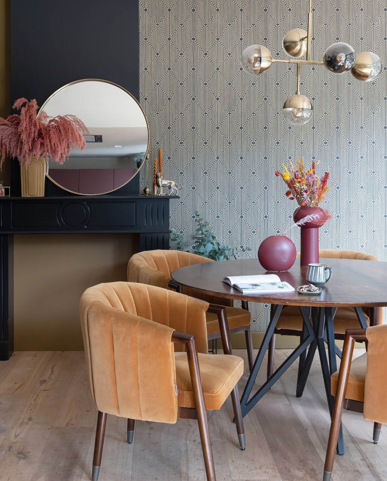 Muurkleur in ‘haard’ Autumn Gold van Histor. Muurkleur op schouw Parcours en vliesbehang De gouden kunst van Sublime via Praxis. Spiegel Curve van Kare Design, vaas op schouw Pt Living, pampasgras in Roest De Gier Bloemen, kandelaars Fést Amsterdam en H&amp;M Home. Kaarsen, mok en tijger Sissy-Boy. Stoelen Tammy van Dutchbone, tafel Studio Henk, lamp Globular BePureHome, vazen op tafel Kwantum, schaaltje HKliving. vtwonen 02-2023 | styling Sharon Roest | fotografie Caroline Martinot