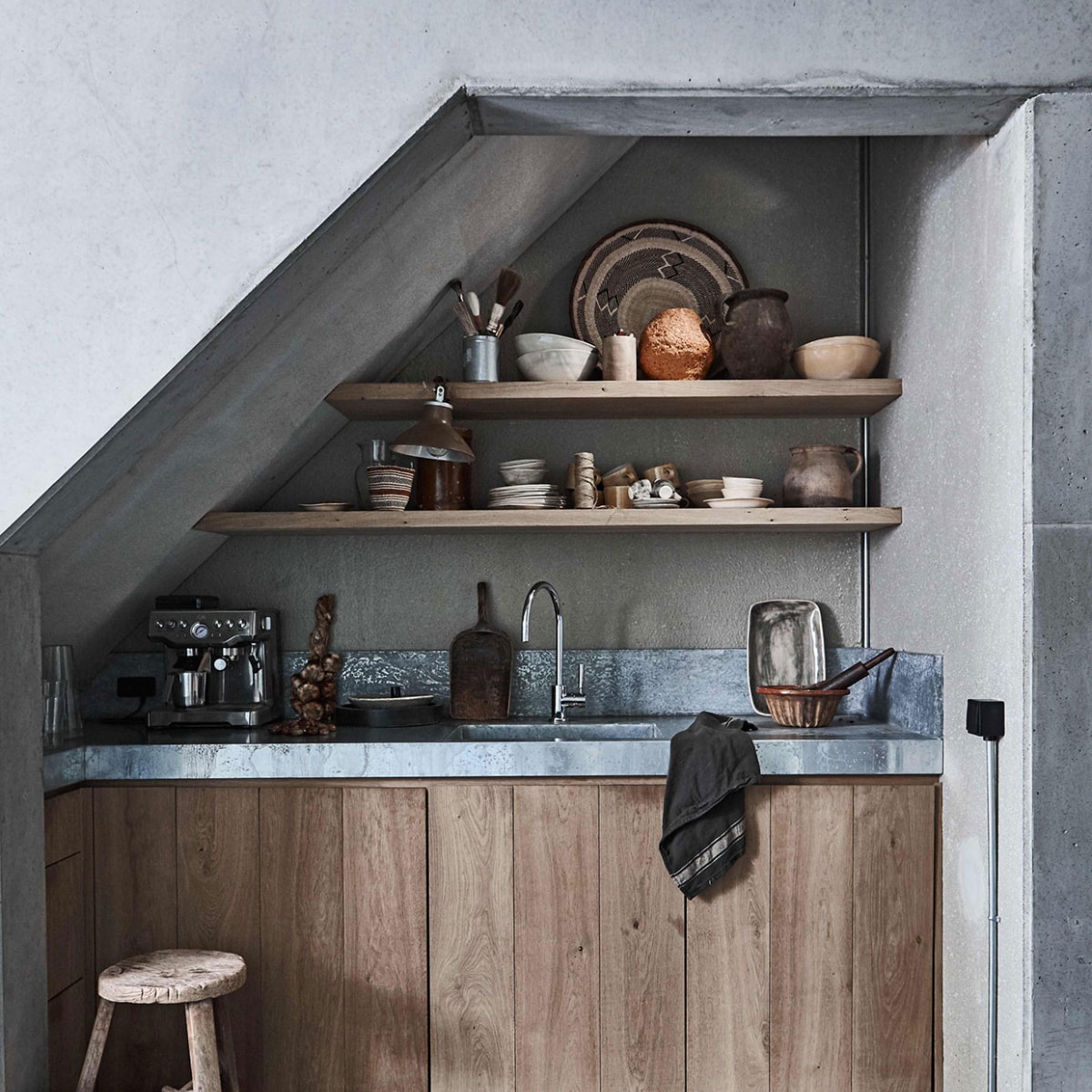 Servies van Wonki Ware, houten krukje uit Azië, rieten mand op grond, aardewerken potten, keuken (). Schaal Binga op bovenste plank, kleine gestreepte mand Kenya, vintage houten schep (). Knijplamp, kwasten (). Tulband bakvorm van aardewerk (). Deegroller (). Theedoek Vardagen (). Overig privéb vtwonen 01-2017 | Fotografie Jeroen van der Spek | Styling Cleo Scheulderman