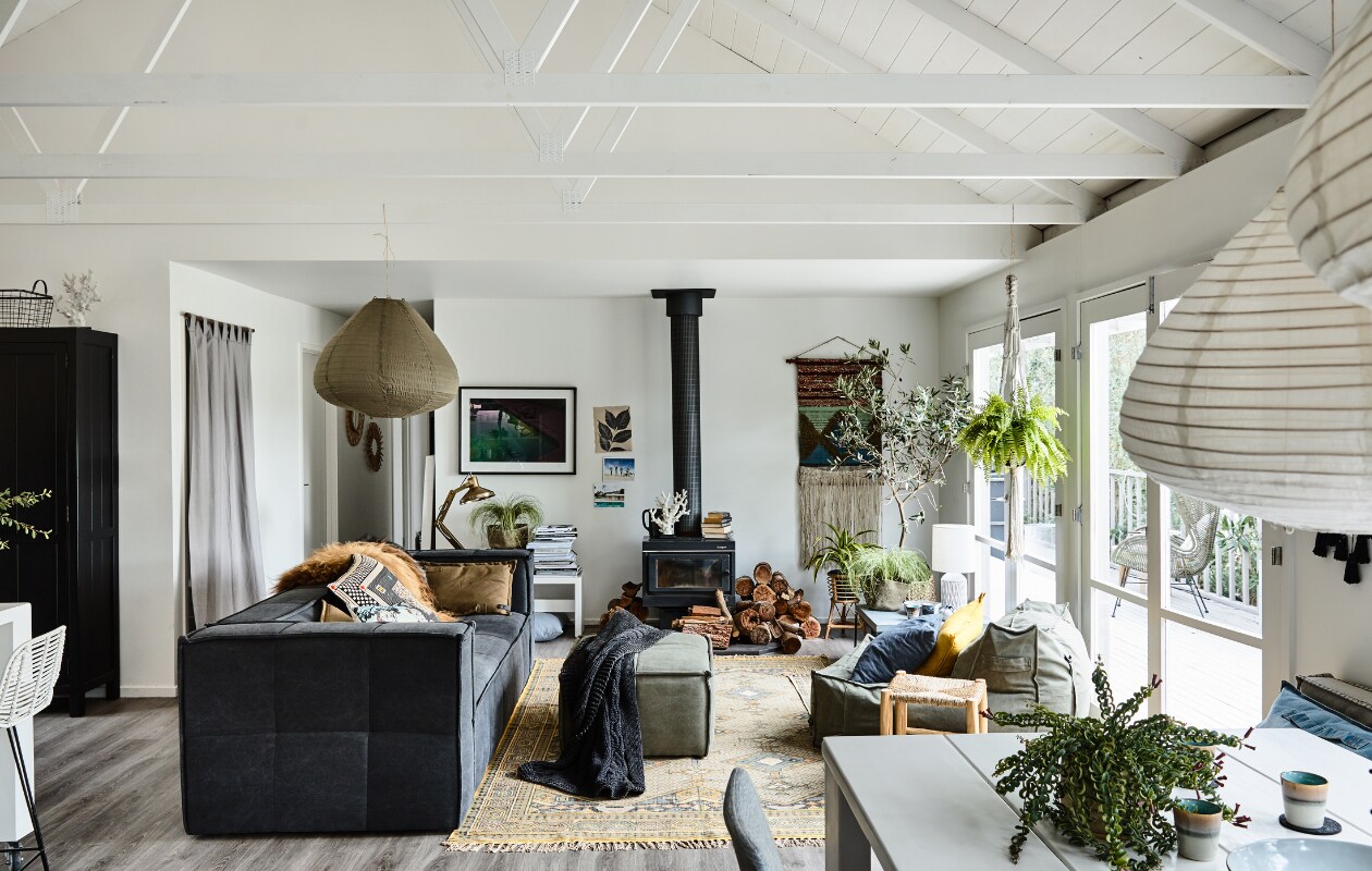 Banken, lampen, kleed, kast en wandkleed van HK Living. Tafel van House of Orange. Foto aan de muur van Derek Swalwell, die ook de foto’s van het huis maakte. De kachel zat al in het huis. Op de vloer Belgisch lamelparket. In de hoek staat een olijfboom in pot. Overig vintage gekocht in de buurt. vtwonen 08-2018 | Styling Rachel Vigor | Fotografie Derek Swalwell | Tekst Ina Babbé