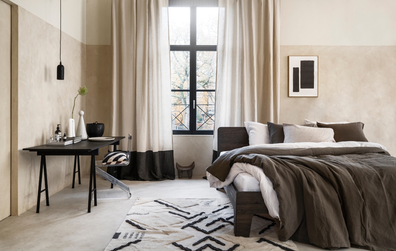 Stucco-look muurverf Mykonos, 2,5 liter € 110,- (wearewowmakers.com). Gordijn gemaakt van linnen Cloud Rider van Chivasso, per meter € 114,50 (jab.de). Bedombouw Pure, eiken fineer in Charcoal olie, 180x200 cm (bxd) € 3400,- (loof.nl). Duurzaam gewassen linnen dekbed-overtrekset met smalle strepen, 240x220 cm € 329,- (yumeko.nl). Bruine dekbedovertrekset, duurzaam linnen en katoen, 240x220 cm € 179,95 (suite702.com). Vloerkleed, 260x160 cm € 399,- (malagoon.com). Tafel van Serax, 150x75x73cm (lxbxh) € 824,-, vaas met bolvormig deksel van Ferm Living € 85,-, schaal Omhu van Ferm Living € 105,- (flinders.nl). Vintage transparante zigzagstoel € 350,- (neeflouis.nl). Hanglamp € 79,95, pot met oor € 62,95 (urbannatureculture.com). Vaas met twee poten van vtwonen € 49,95, gestreept kussen van Oyoy € 54,99 (vtwonen.be). Poster met lijst vanaf € 95,- (loods5.nl). Afrikaans krukje privébezit. vtwonen 03-2023 | styling Marianne Luning | fotografie Stan Koolen | assistentie Pom Rezelman, Evans van der Sluis | naaiwerk Meta Poulain